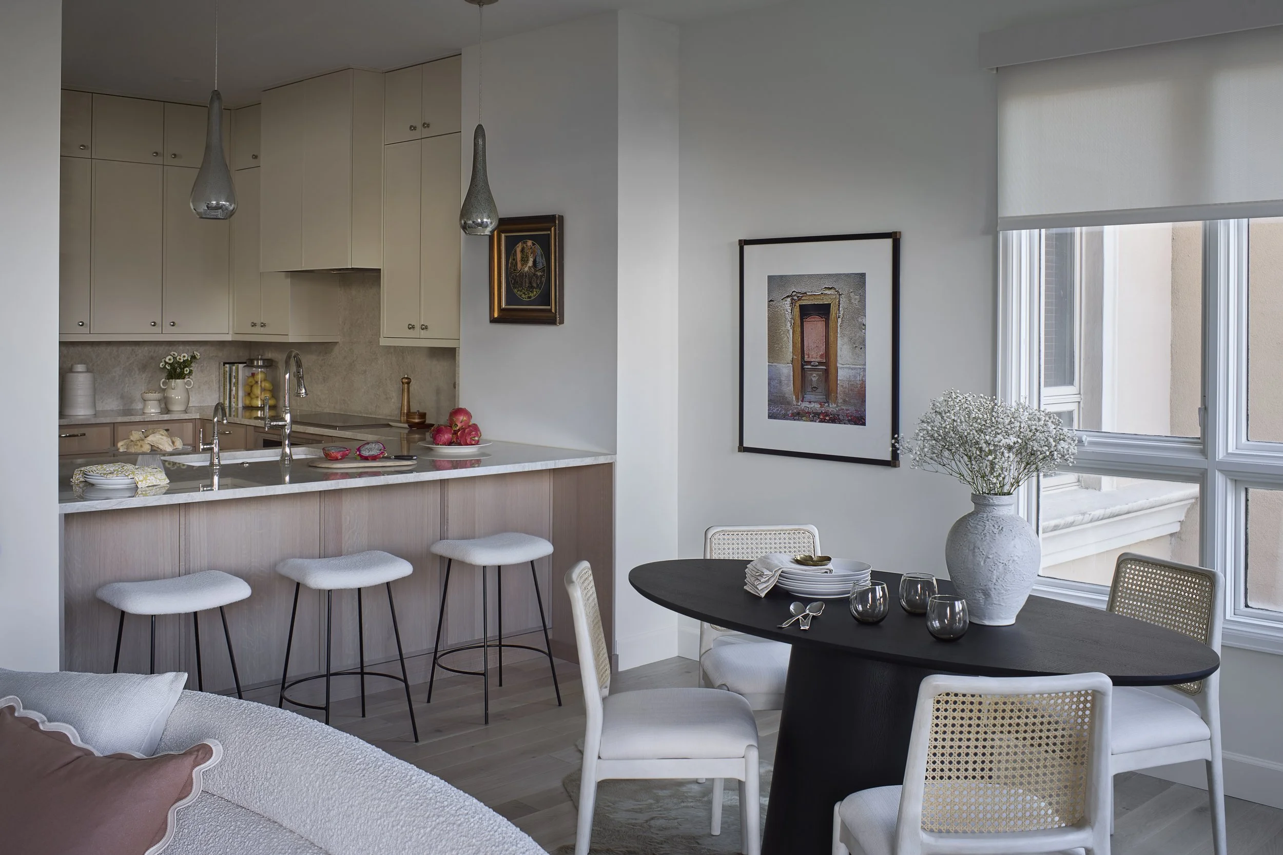Open kitchen and dining area designed by Flemming Interiors as part of a full condo renovation in Cherry Creek, Colorado, featuring custom cabinetry, integrated seating, and curated furnishings.