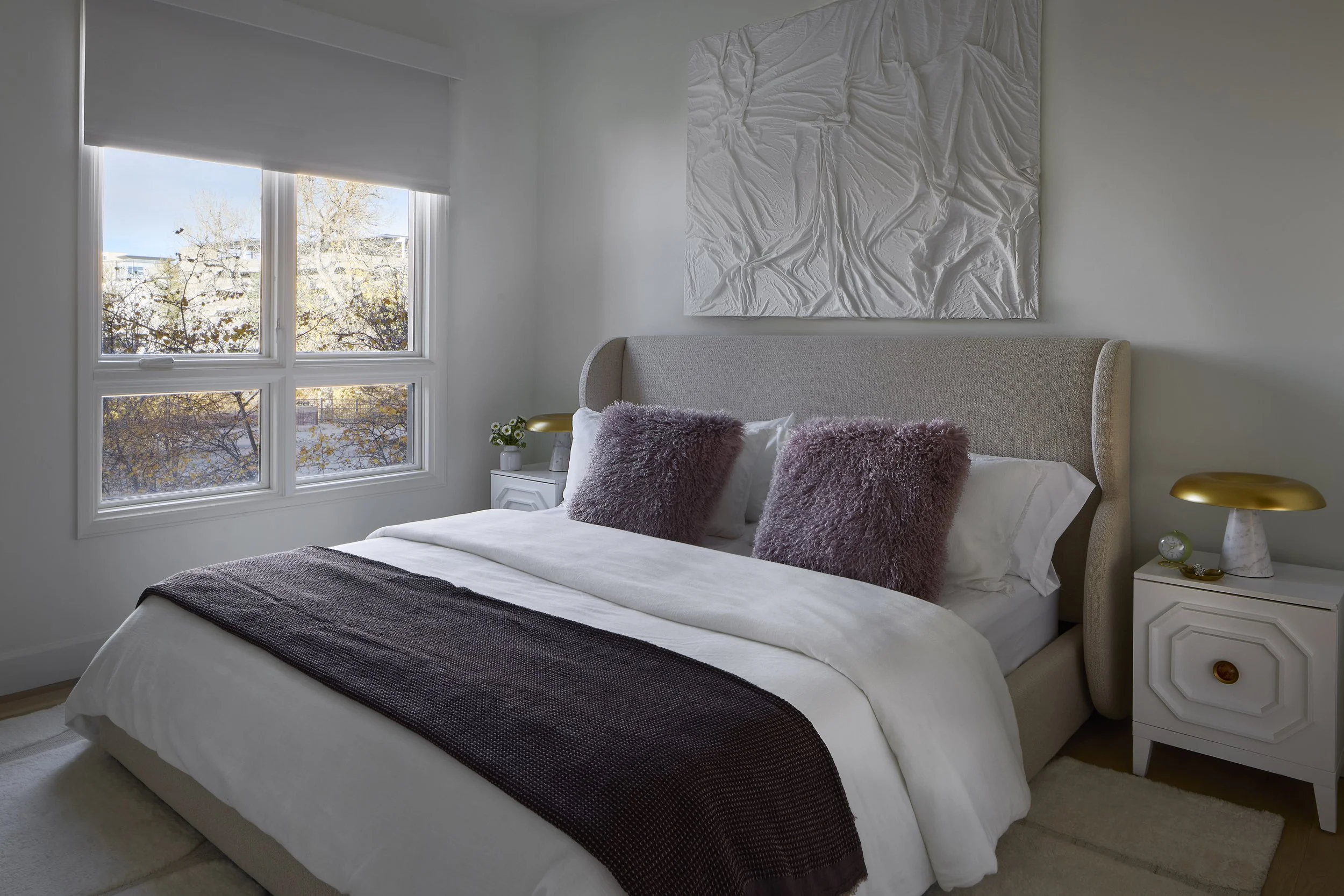 Primary bedroom designed by Flemming Interiors as part of a full condo renovation in Cherry Creek, Colorado, featuring an upholstered bed, layered textiles, and custom furnishings.