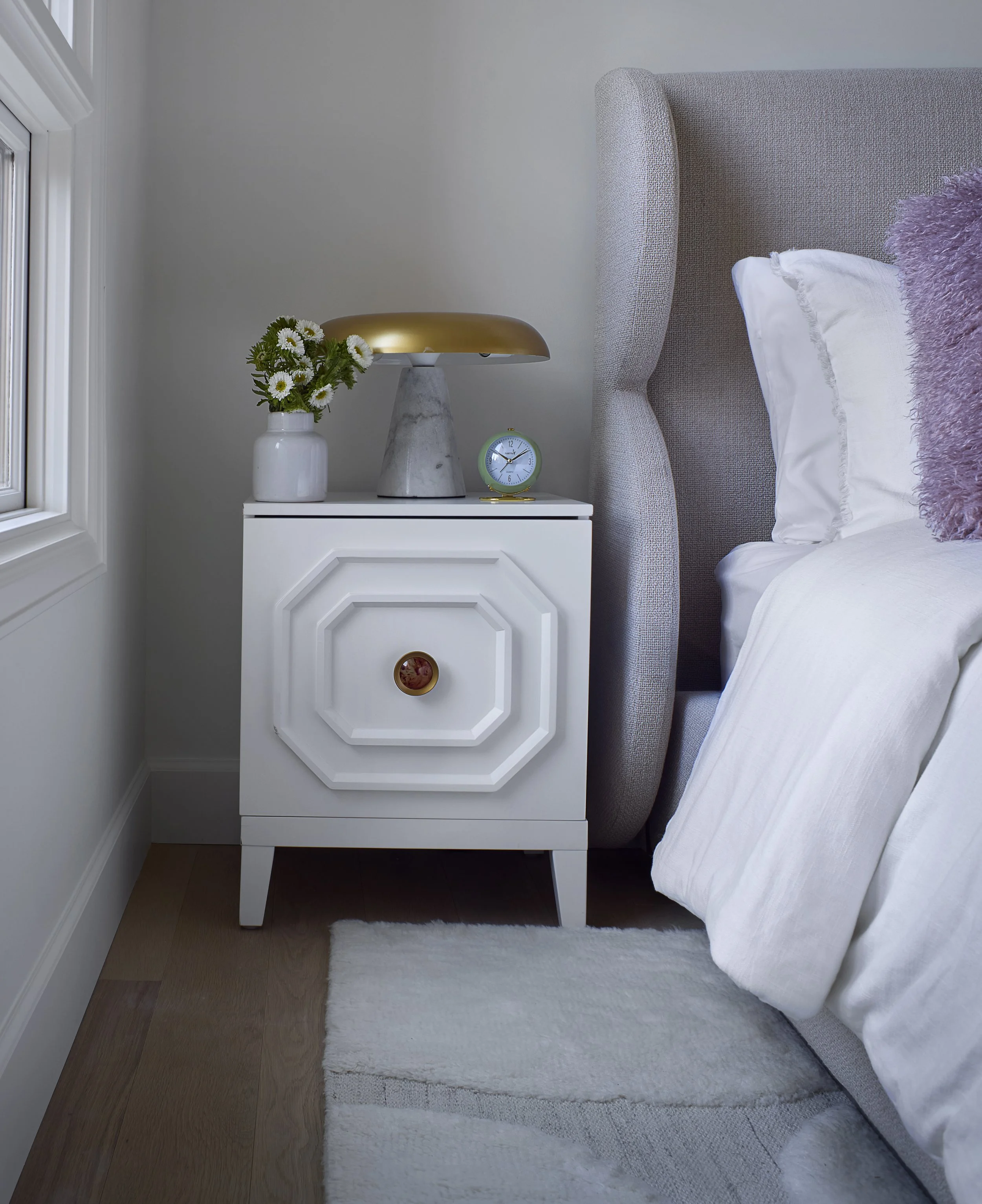 Primary bedroom detail by Flemming Interiors in a Cherry Creek condo renovation, featuring a custom nightstand, upholstered headboard, and carefully curated lighting and accessories.