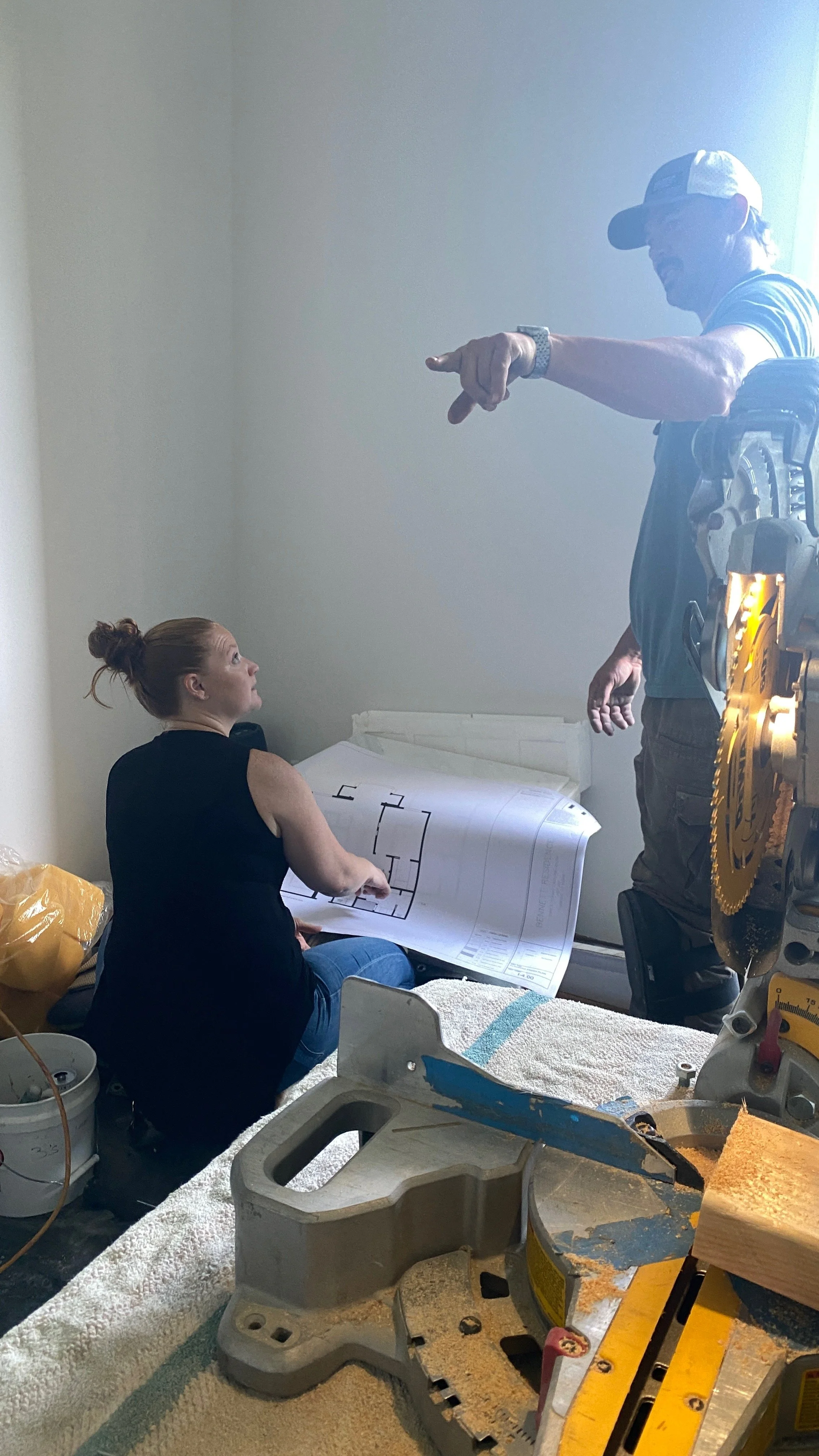 Flemming Interiors reviewing architectural drawings on site during a Cherry Creek condo renovation, coordinating interior architecture details with the construction team.
