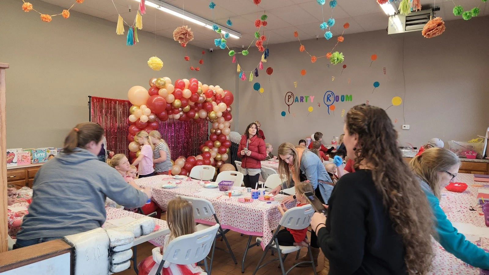 Family gathers around balloon picture op at Baraboo Children's  Museum