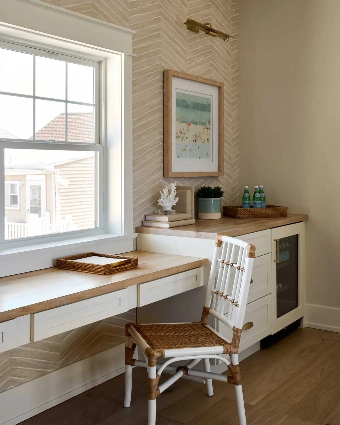 Home office overlooking a window with a cane chair and a three-drawer desk.