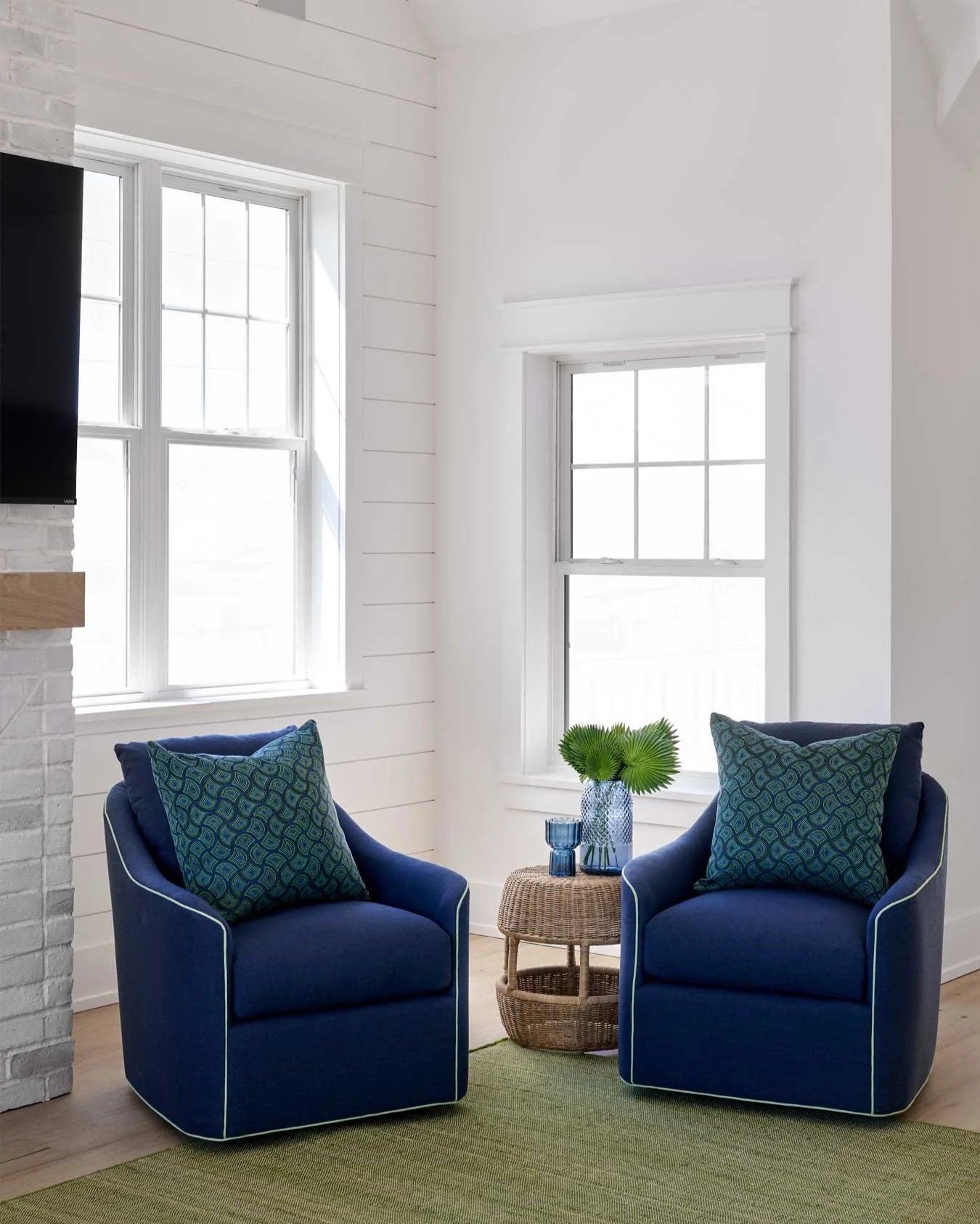 Two blue swivel chairs in a living room.