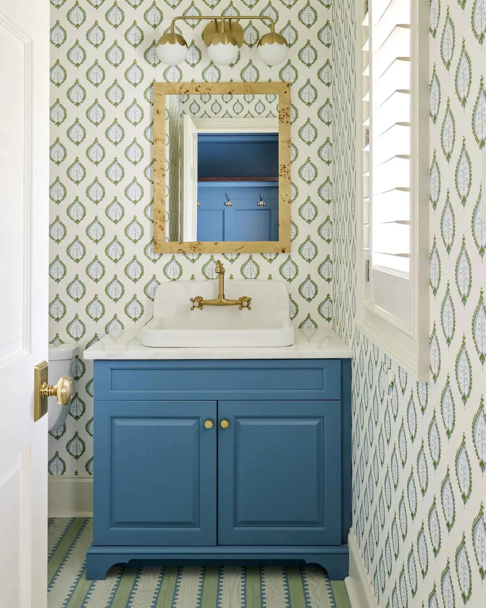 powder-room-with-gold-mirror-and-wallpaper.jpg