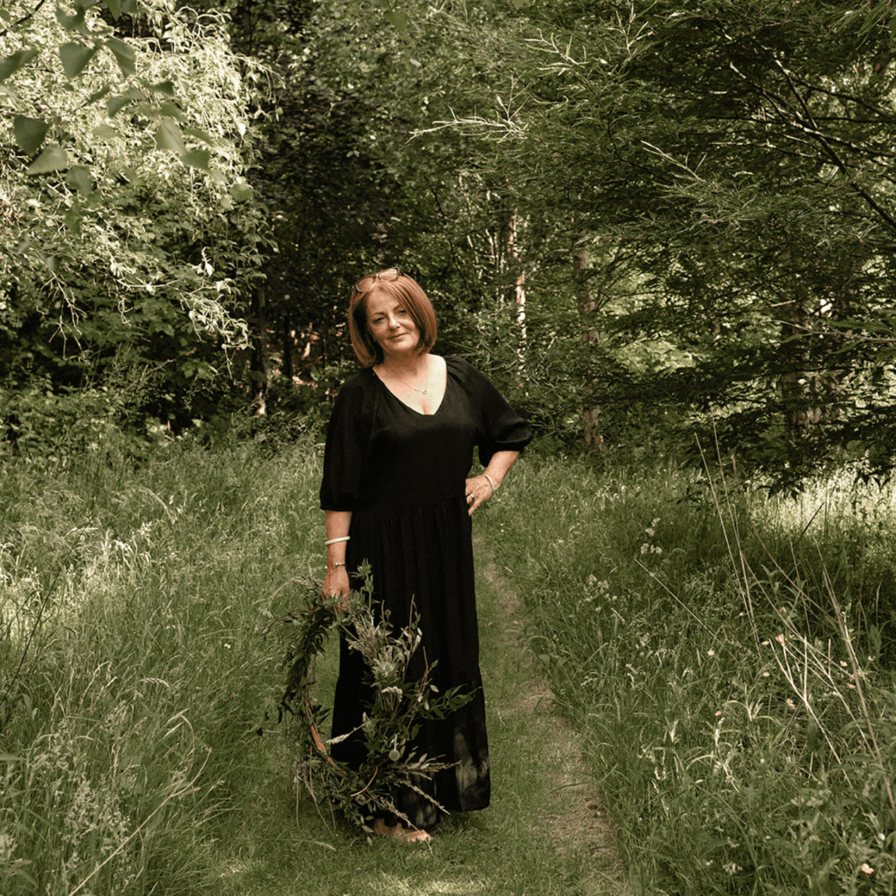 gif-of-woman-holding-flower-wreath-walking-in-a-meadow-path