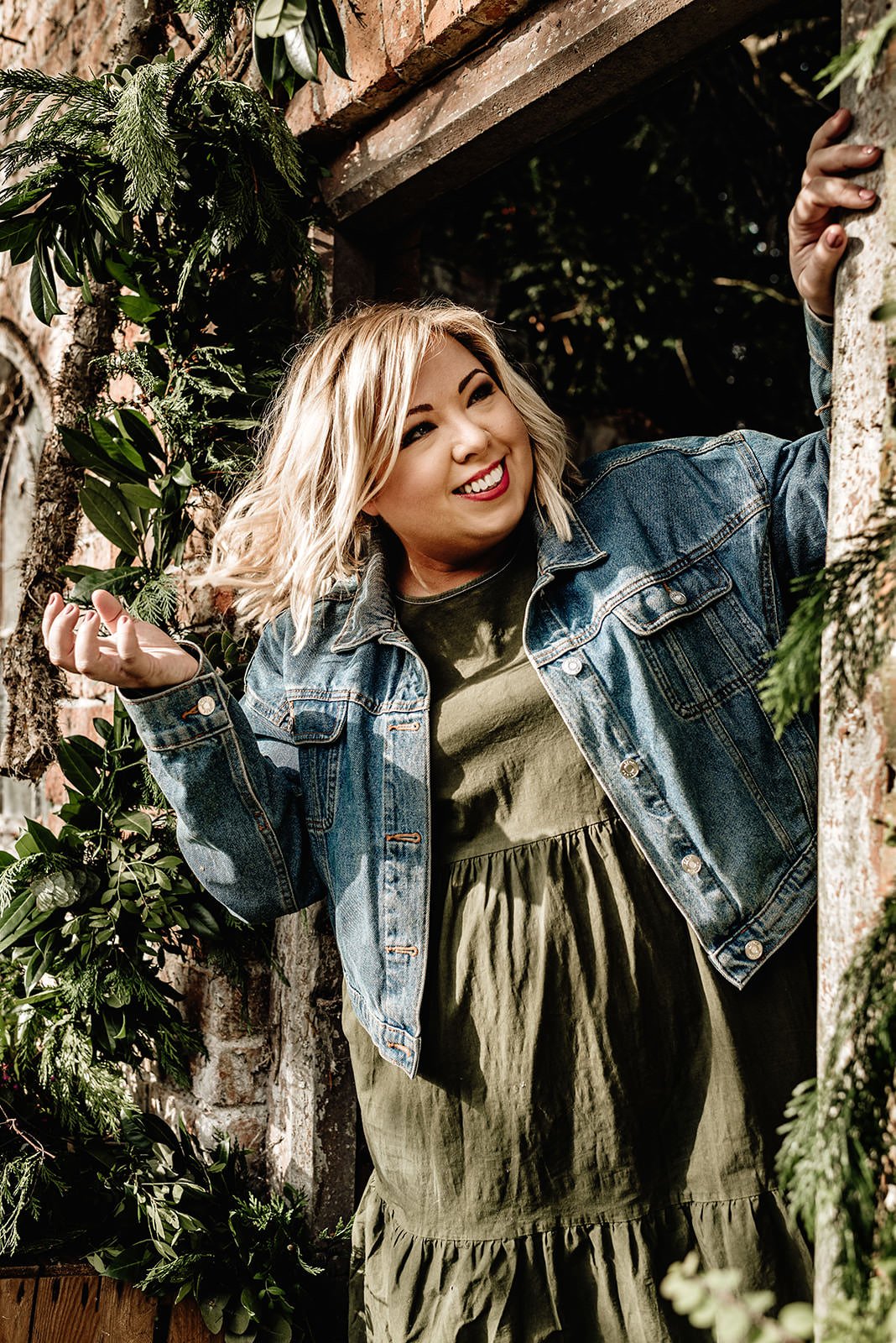 Blonde-short-haired-woman-in-an-old-garden-worshop-doorway-smiling
