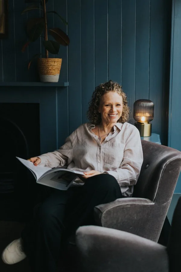 Smiling-woman-sat-reading-a-magazine-in-a-boutique-hotel
