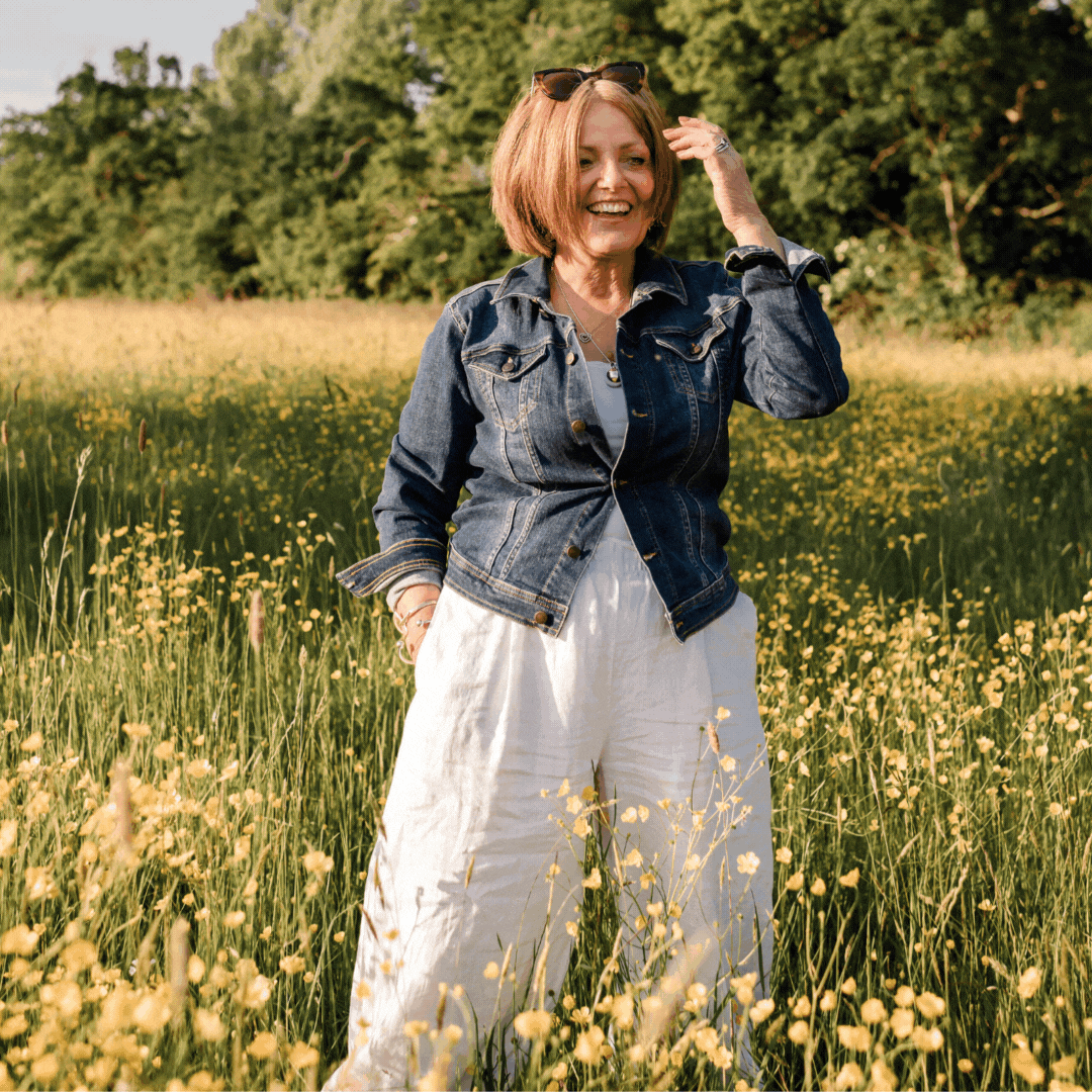 A GIF showing a woman smiling whilst standing in a field of yellow buttercups for her personal brand photoshoot.