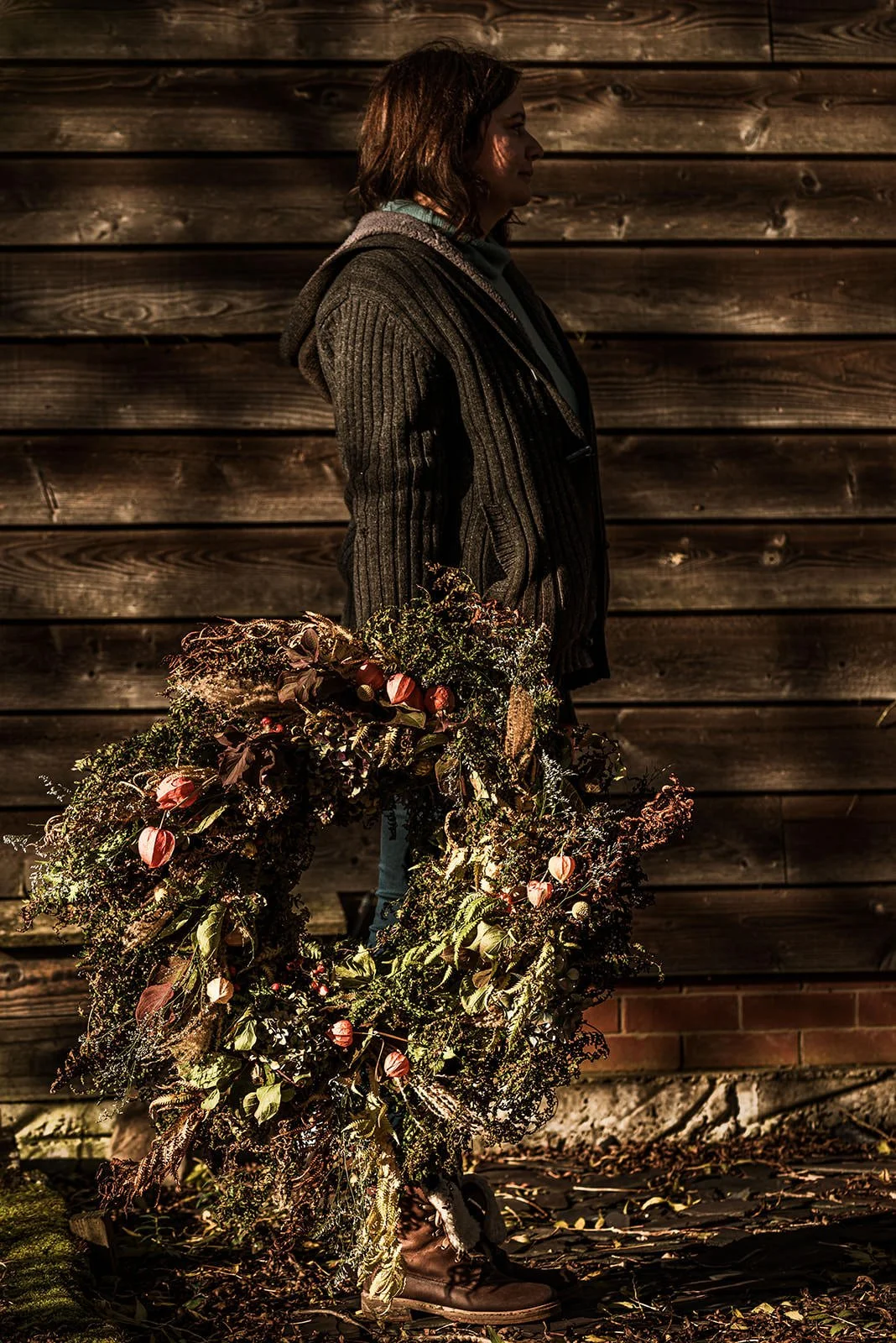 Woman-holding-a-large-autumnal-flower-wreath