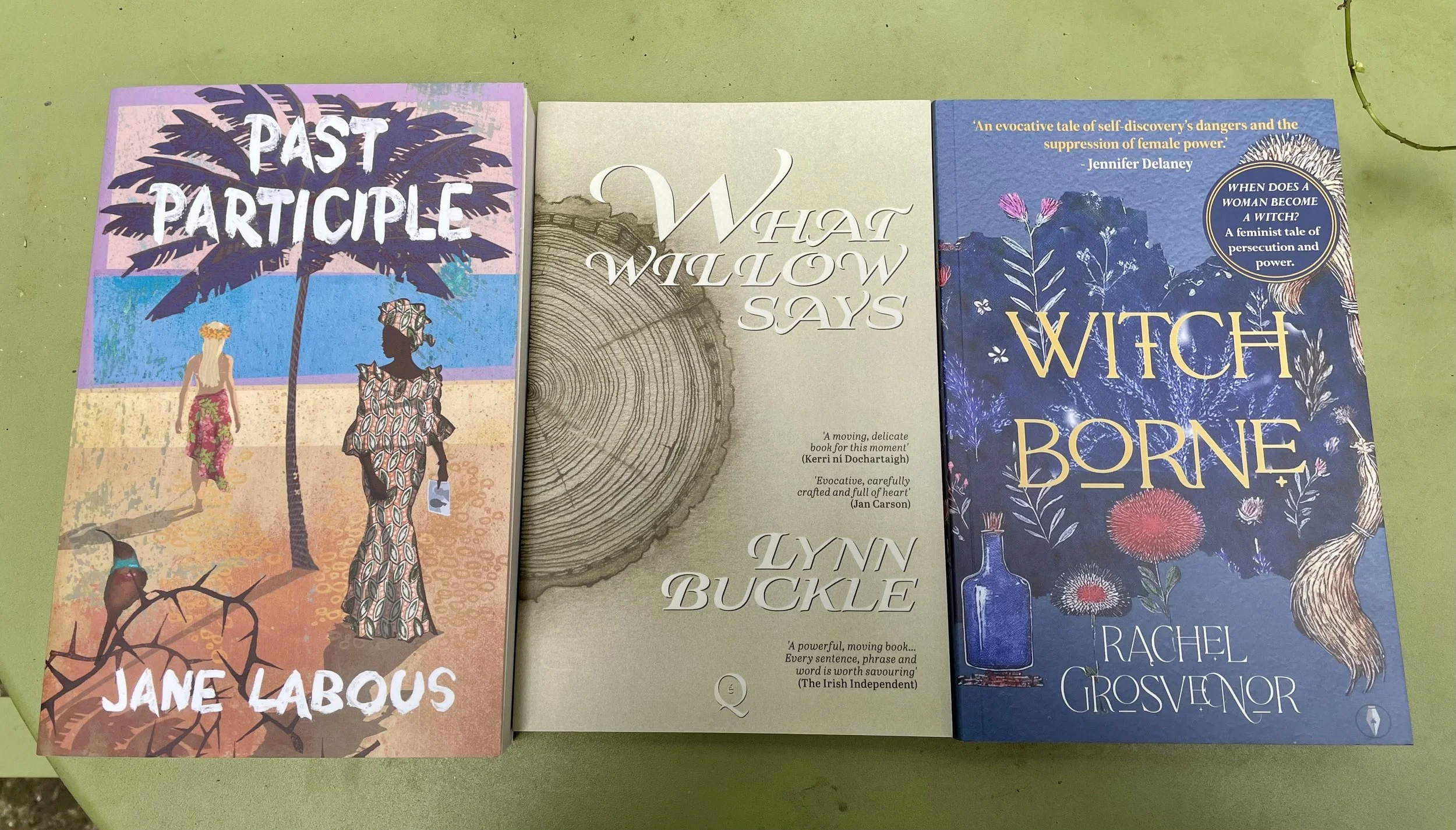 Three novels lying side by side on a table