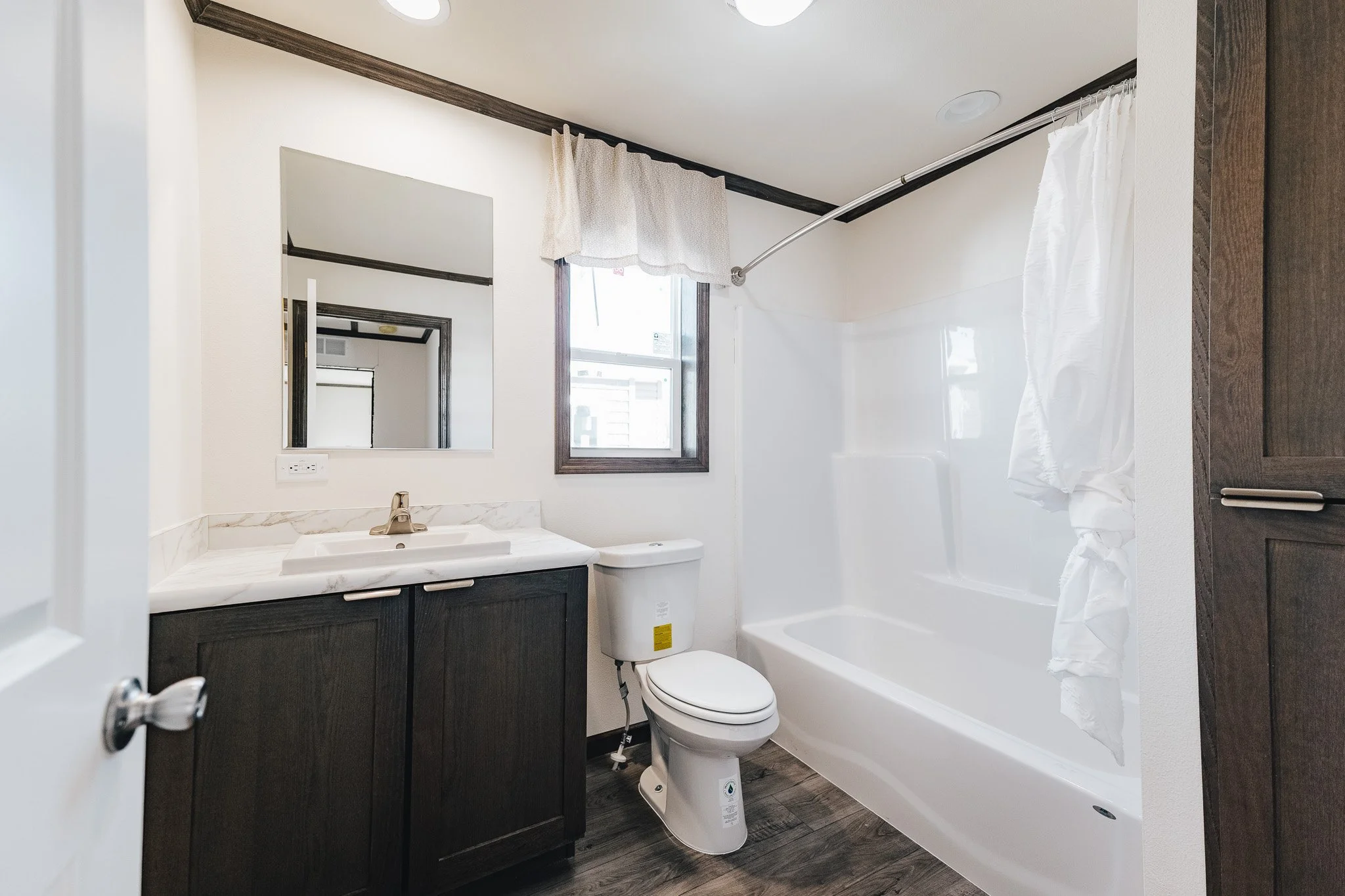 secondary bathroom with single vanity and tube shower combo with stole 