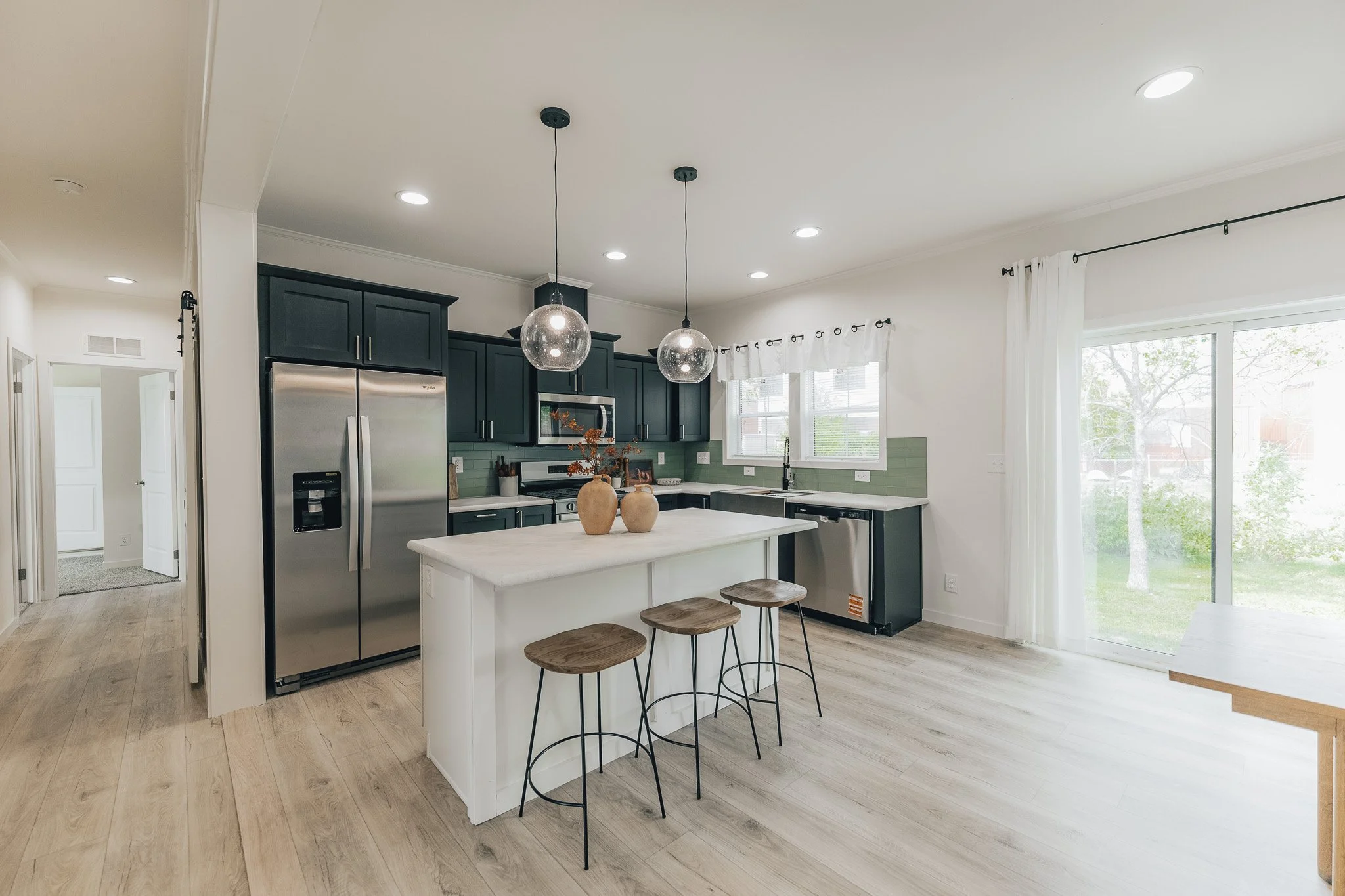 kitchen photo with black and white acents with modern lighting in the cavco farmhouse manufactured home