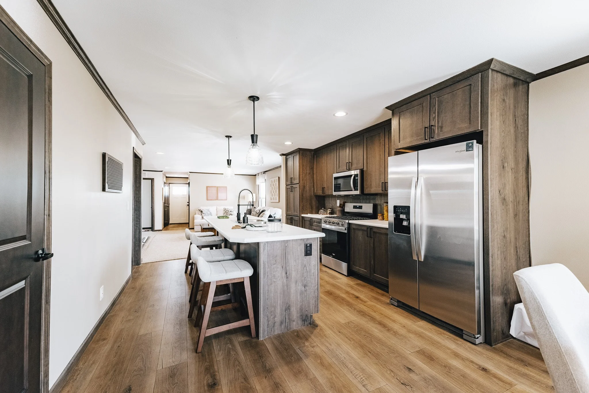 kitchen with brown cabinets and white topped island with sink in it Cavco Westlake Ranch Manufactured Home 