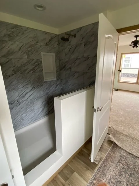 large tiled shower inside the schult roosevelt manufactured home.