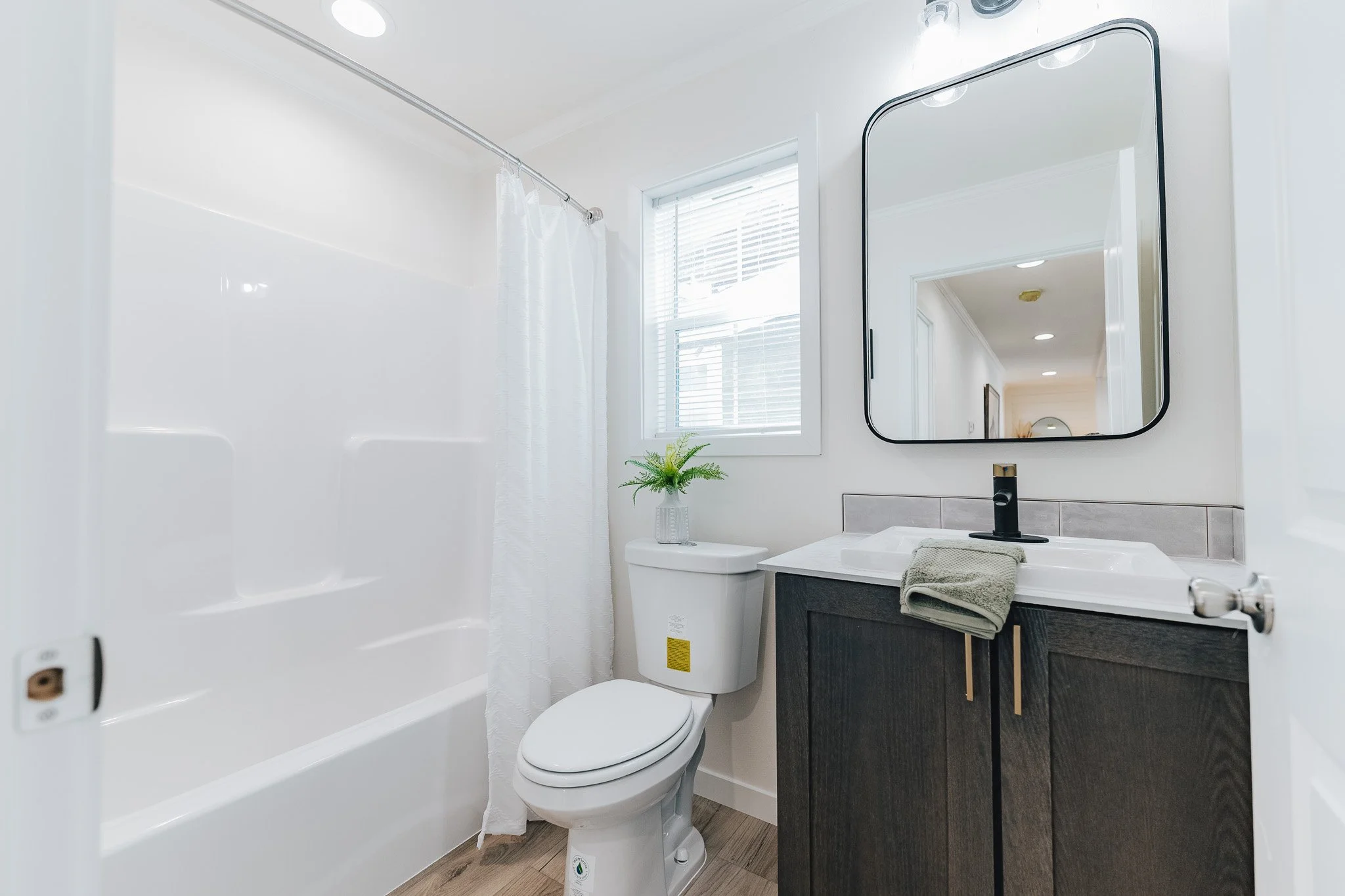 secondary bathroom with single vanity and tub shower inside the cavco farmhouse 