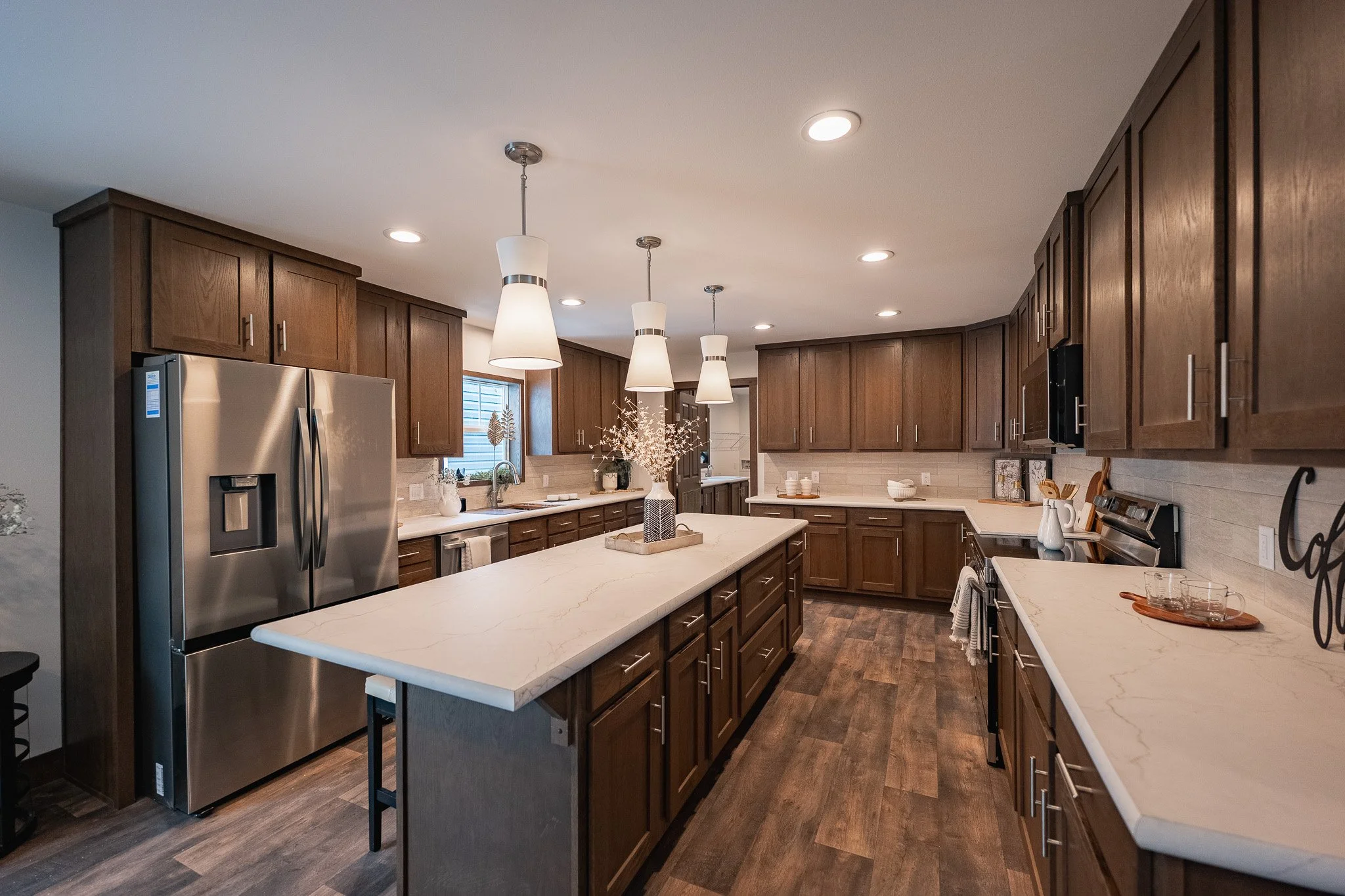 6 seated kitchen island with large counter top space in the kitchen with dark brown cabinetry 