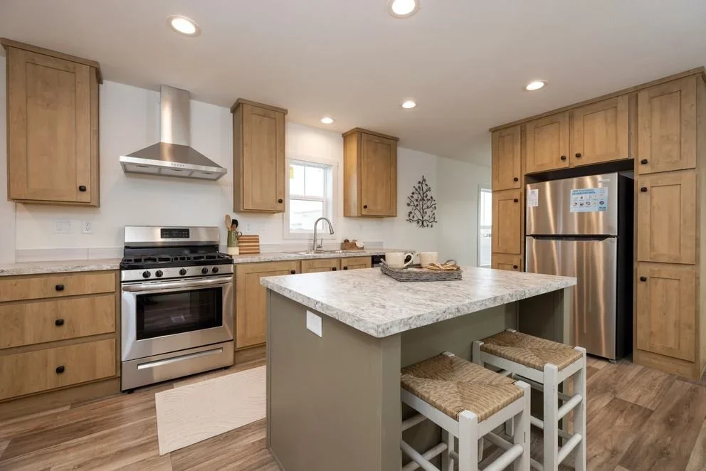 another kitchen photo of the island and sink and appliances inside the johnny b goode manufactured home 