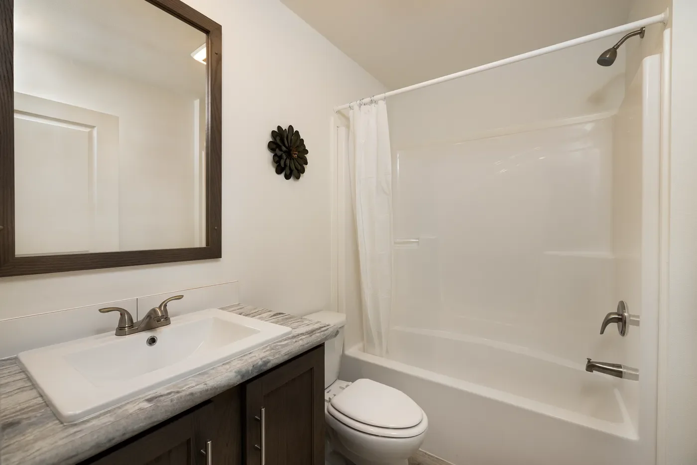 secondary bathroom photo with vanity and tub shower 