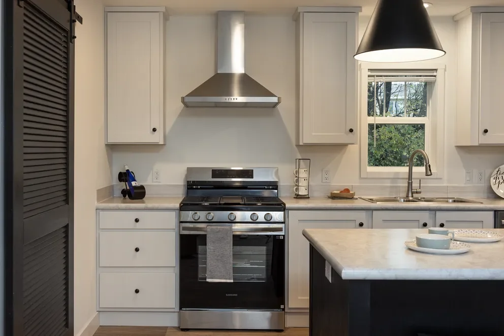close up of kitchen range and vent hood inside the kitchen of the tempo hey jude maufactured home 