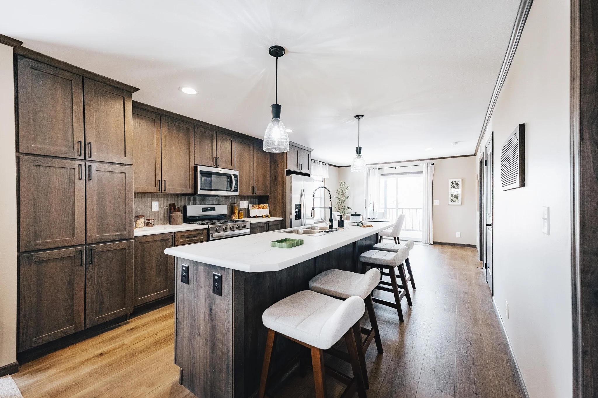 kitchen with brown cabinets and white topped island with sink in it Cavco Westlake Ranch 