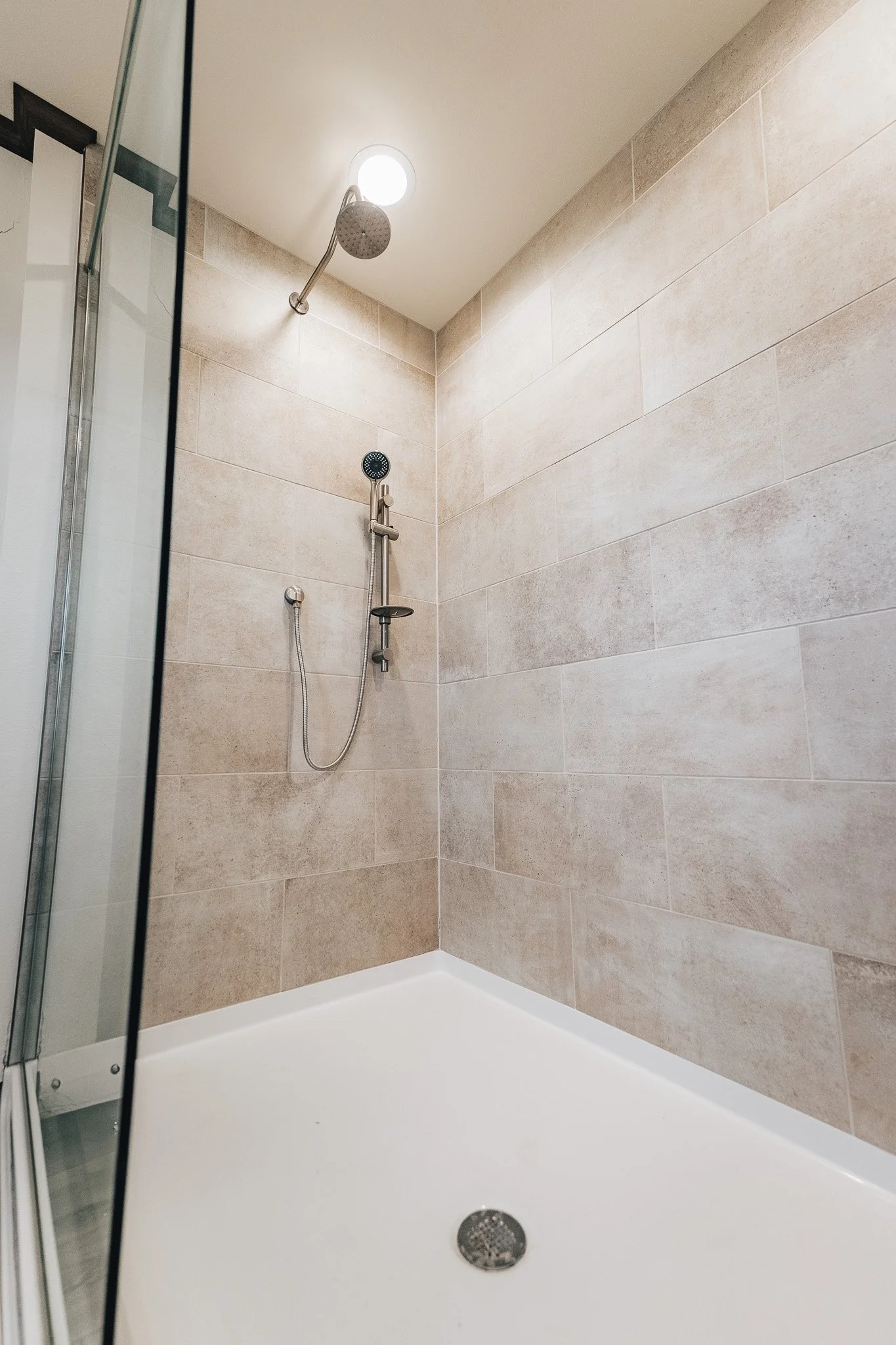 walk in tiled shower withs shower wand 