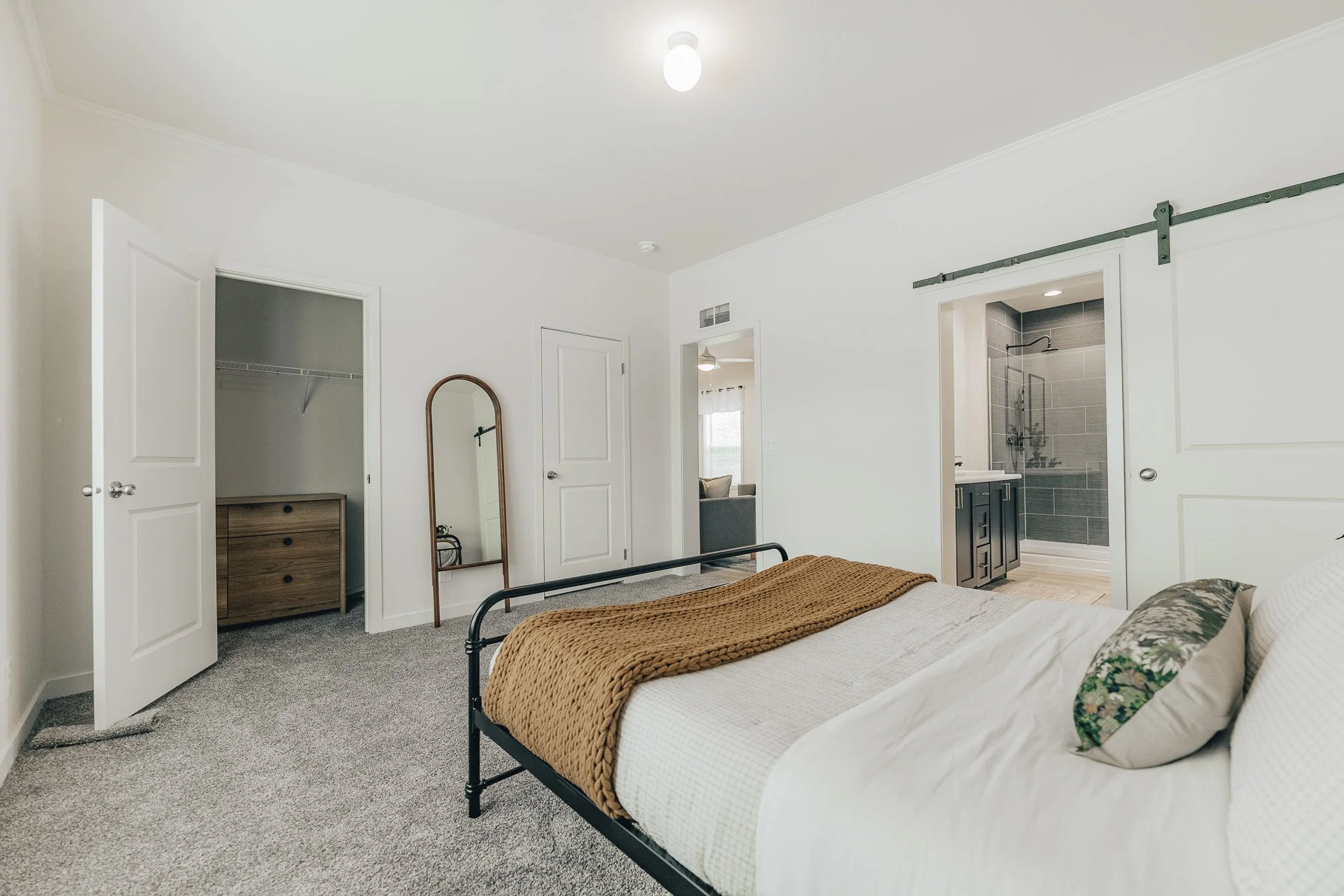 master bedroom photo with bed and barndoor inside the cavco farmhouse manufactured home