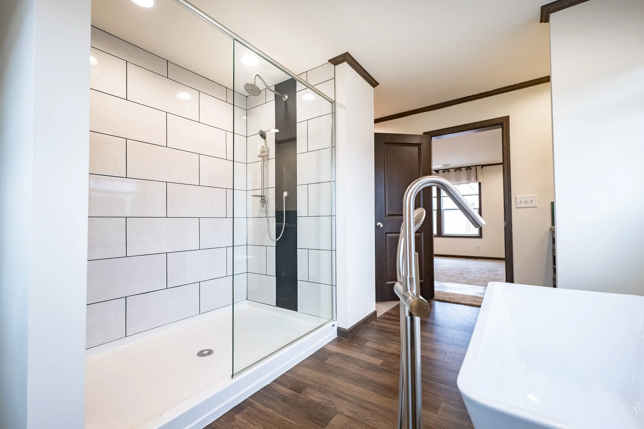 cavco rushmore master bathroom with free standing tub and large walk in tiled shower 