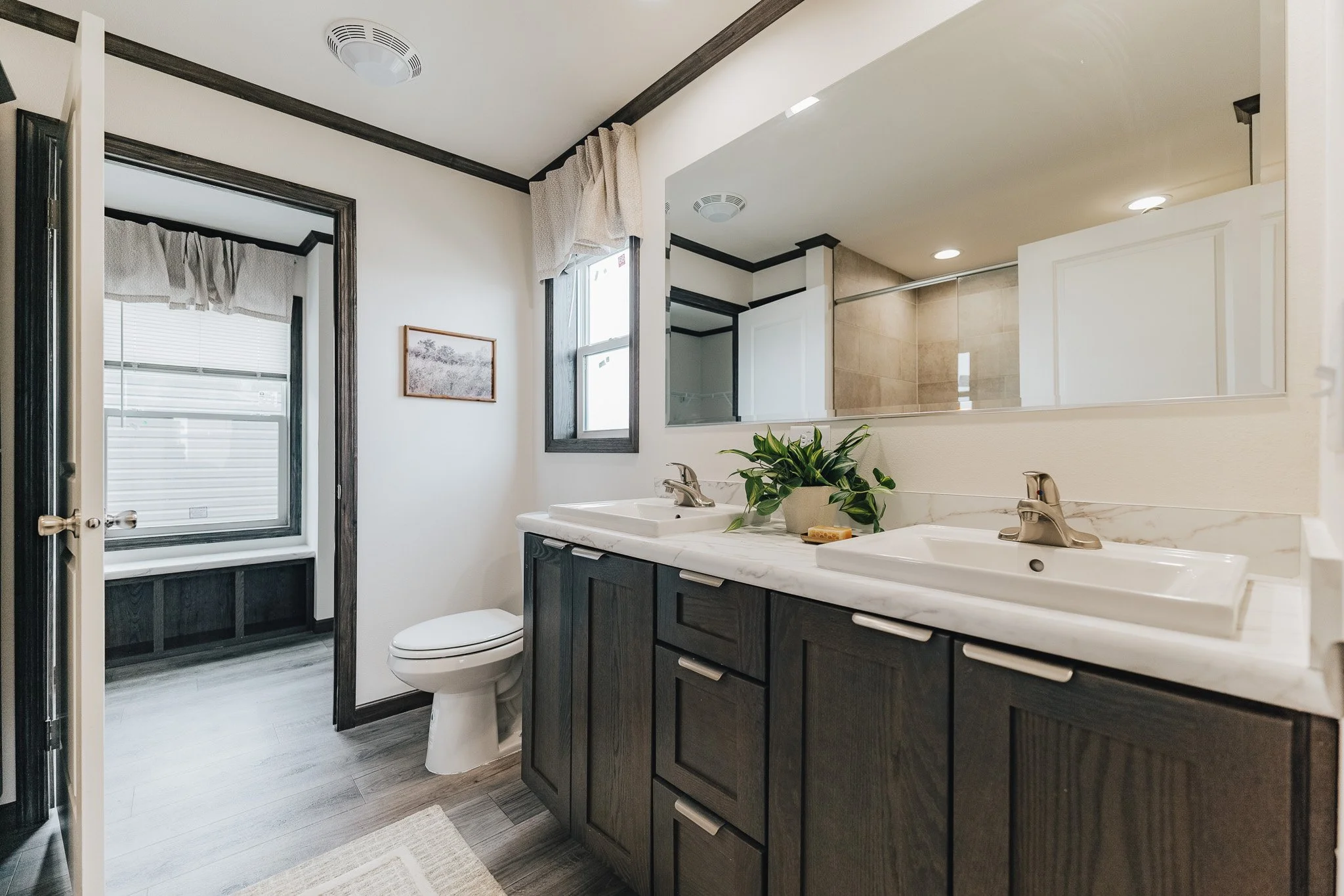 master bathroom with duel vanity with a view into the master bedroom closet