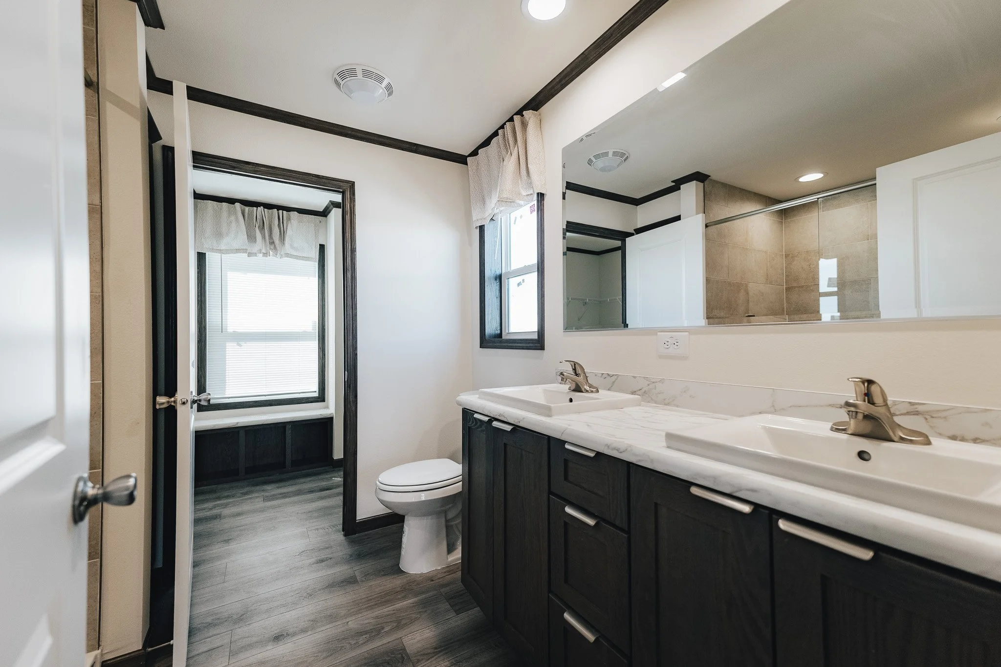 master bathroom with duel vanity with a view into the master bedroom closet