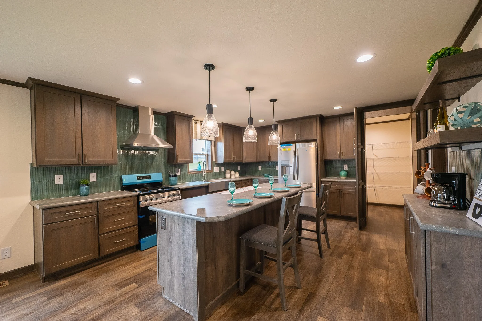Cavco kitchen with brown cabinets and large island with white countertops 