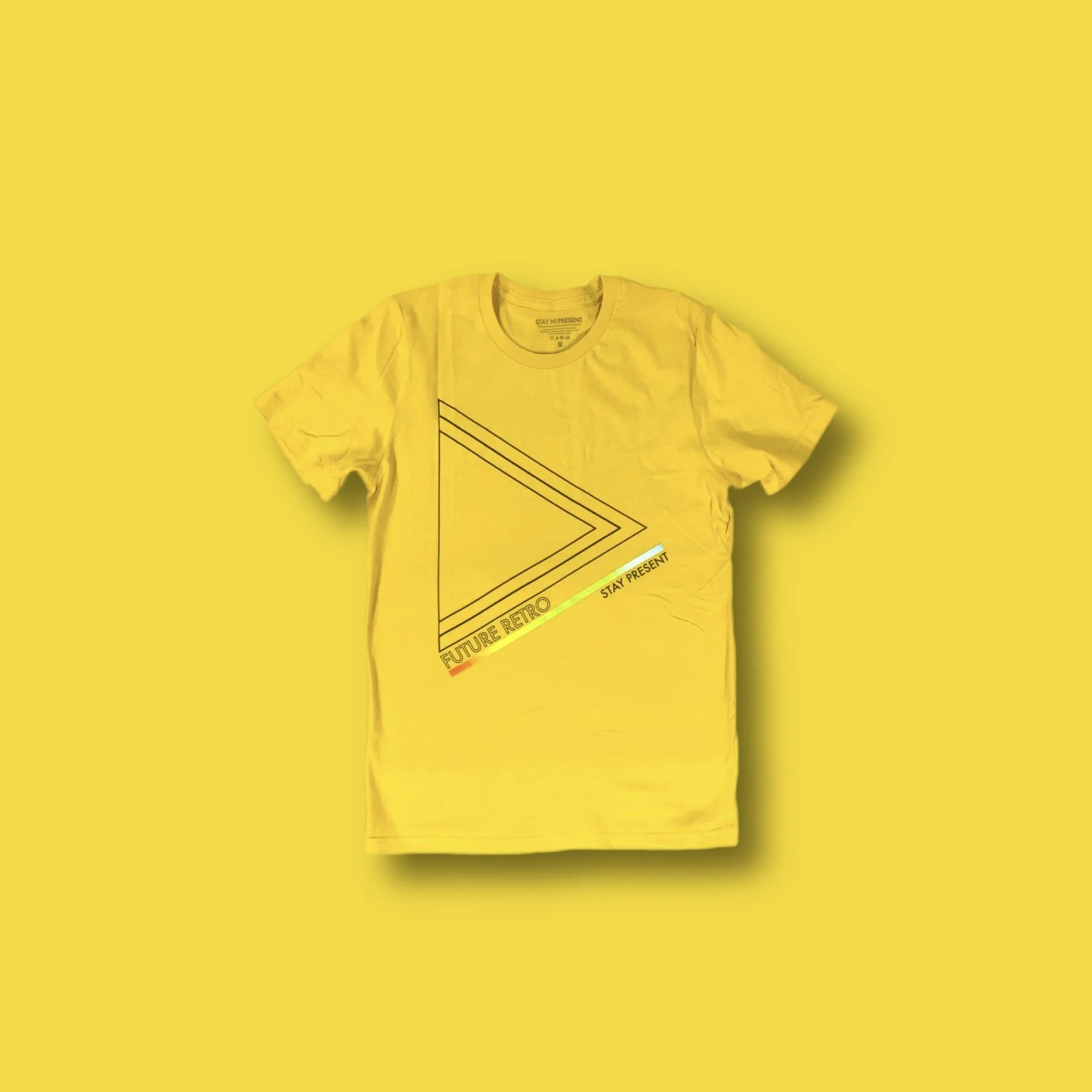 Yellow T-shirt with geometric lines and text reading 'Future Retro' and 'Stay Present' on a yellow background.