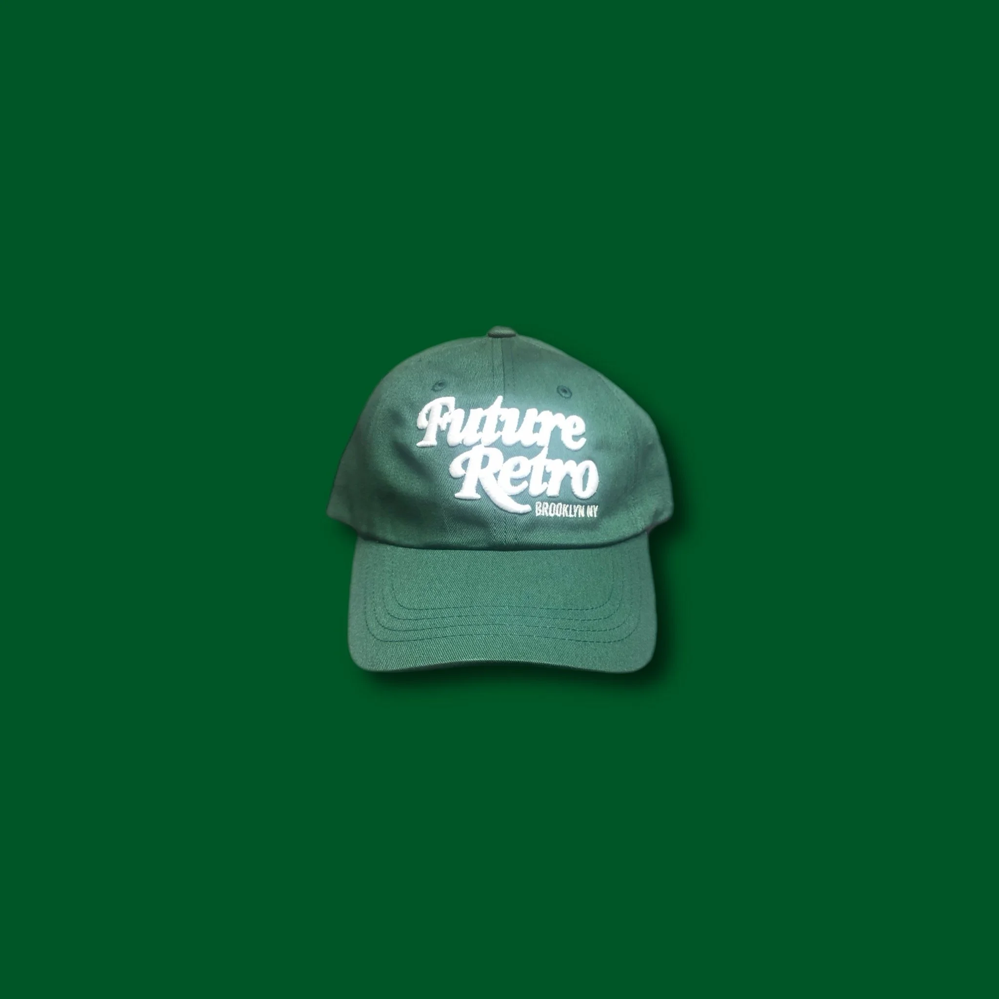 Green baseball cap with white embroidered text 'Future Retro Brooklyn NY' on a solid green background.