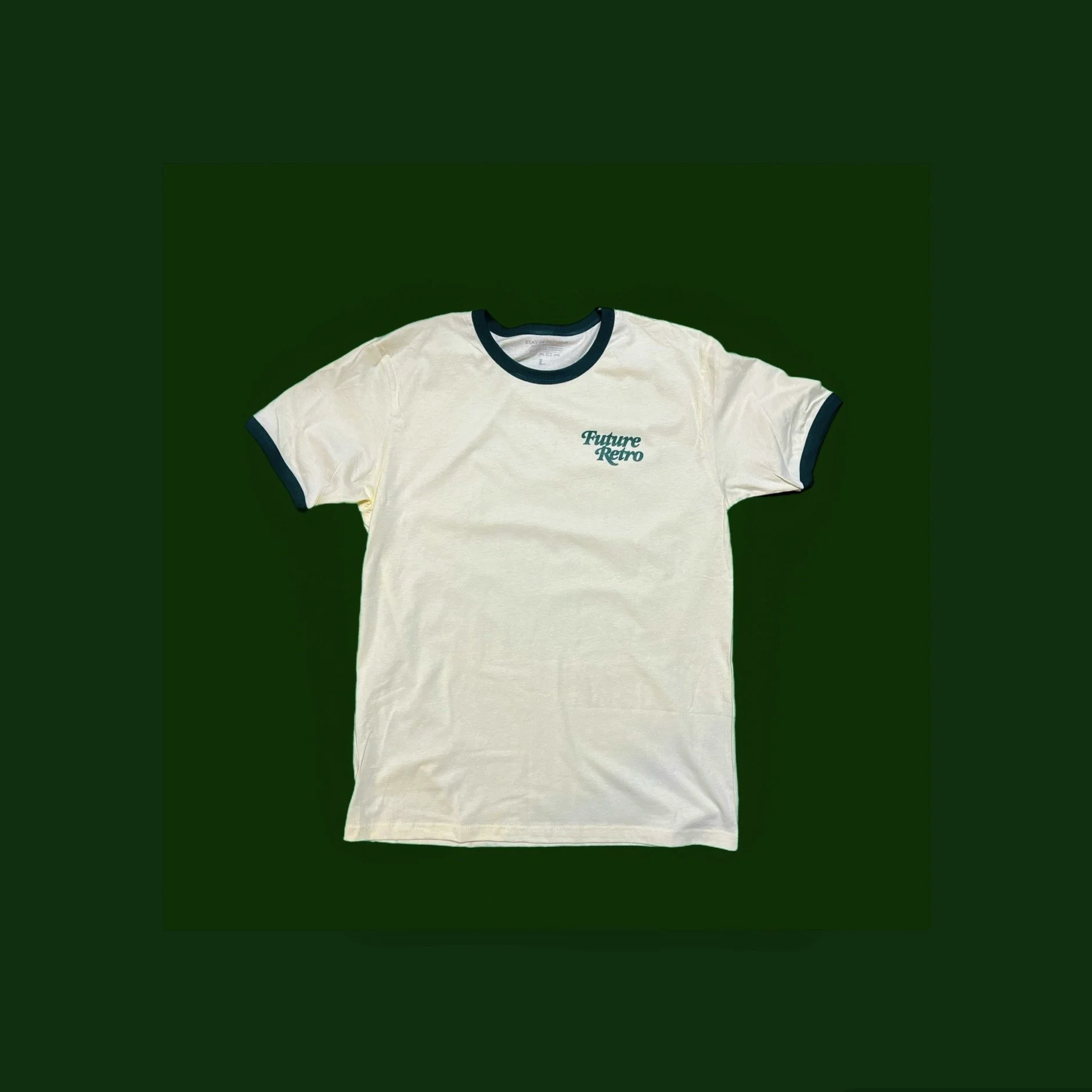 Cream-colored T-shirt with navy blue trim on collar and sleeves, displaying the text 'Future Retro' in teal on the front.