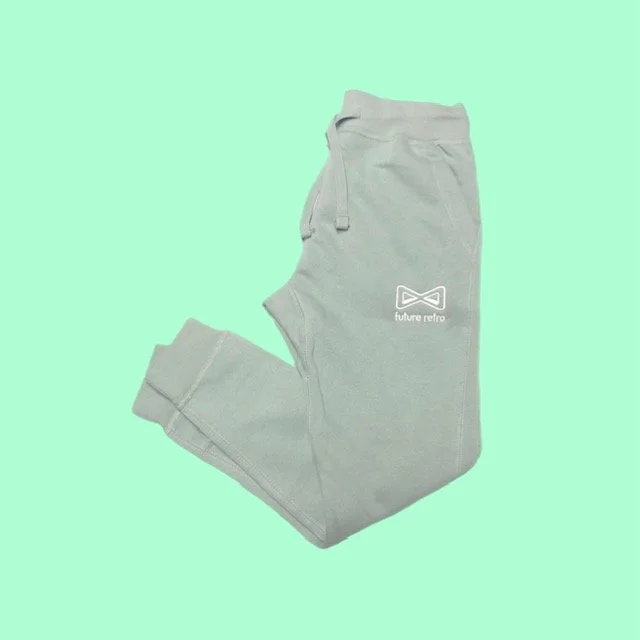 Light gray sweatpants with a small logo and the words 'future refro' on the left thigh area, laid flat against a mint green background.