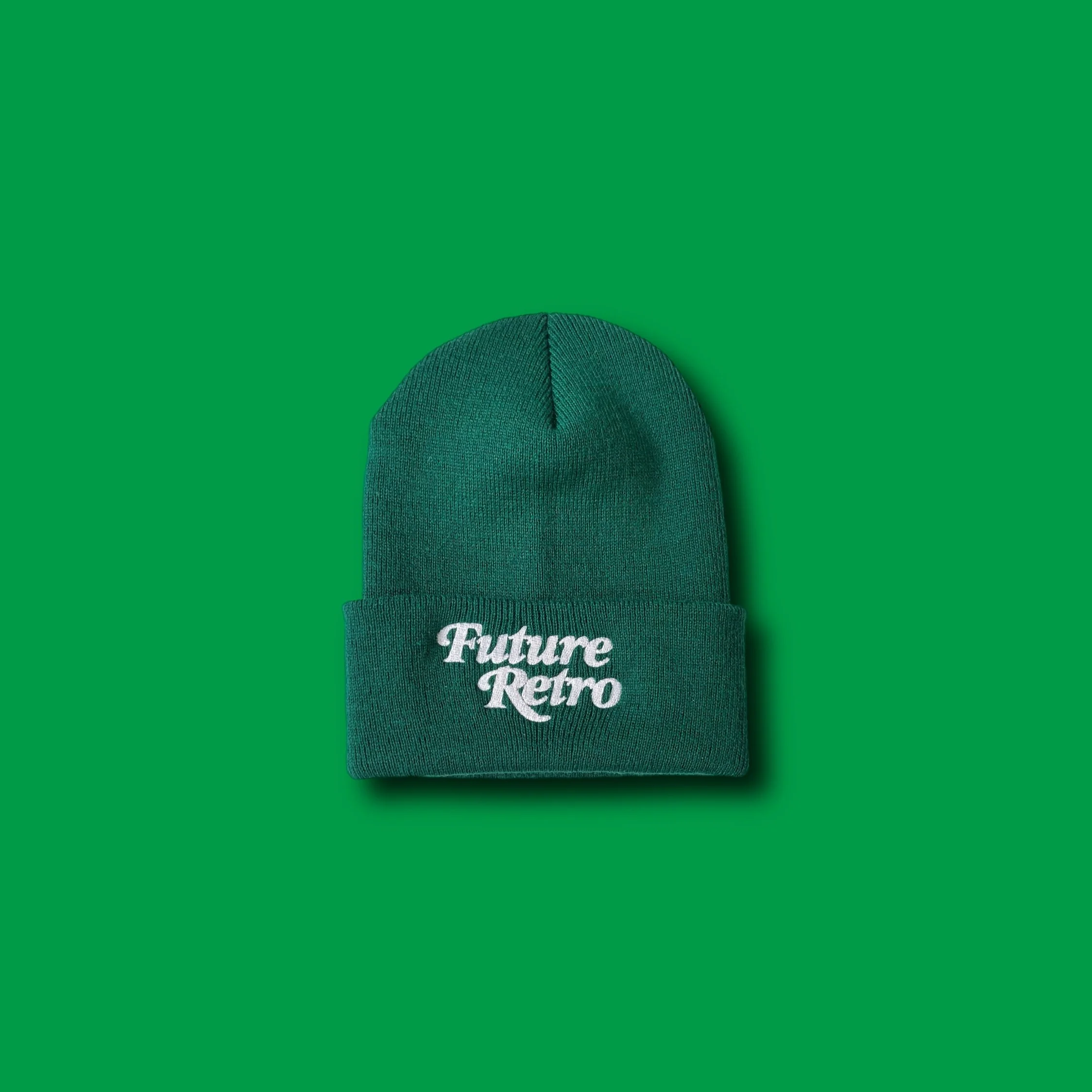 Green beanie hat with embroidered white text saying 'Future Retro' on the front, placed on a green background.