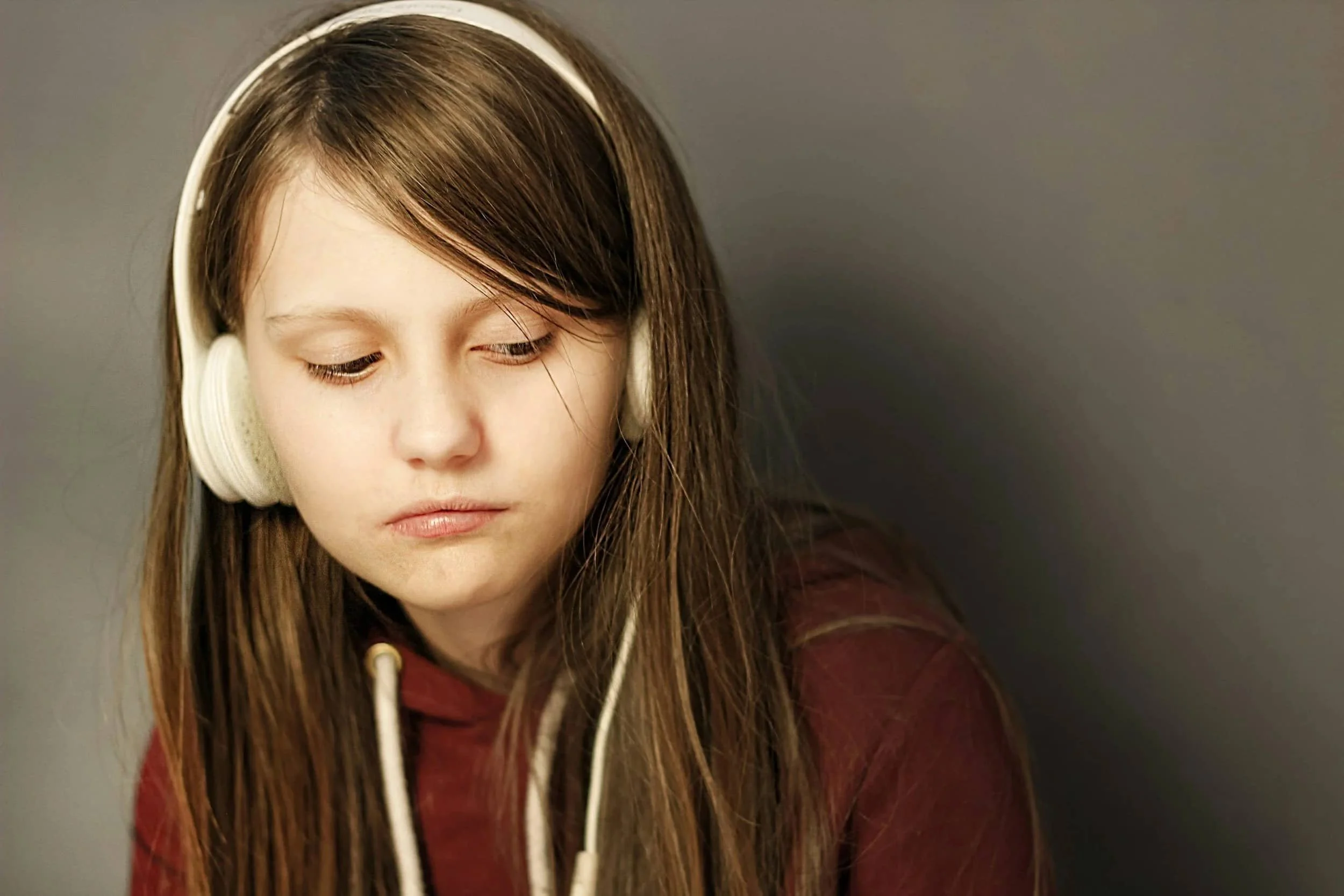 Teenager listening to music with headphones getting therapy to help with anxiety and depression to build self esteem and coping skills.