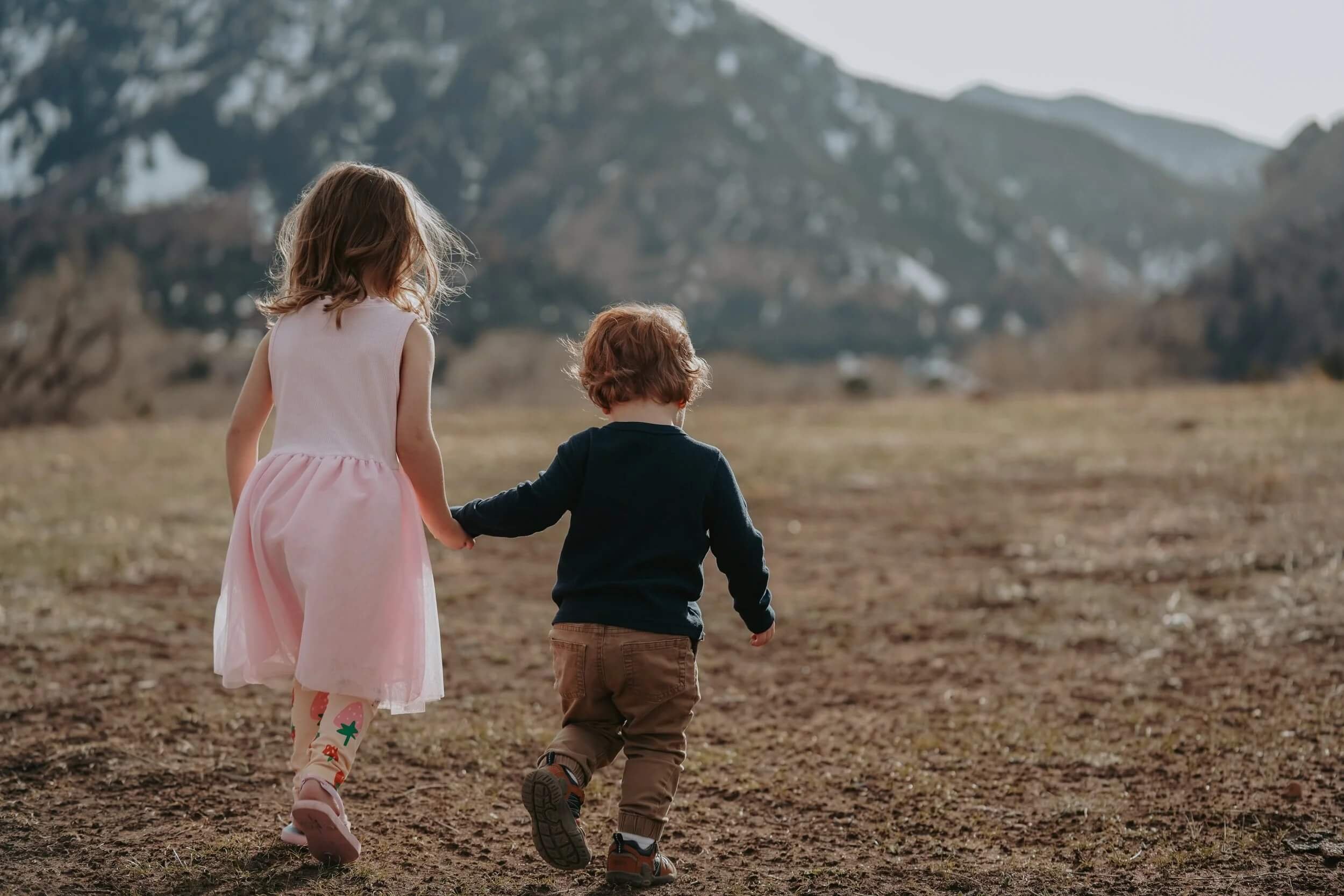 Two kids running in nature emotionally regulated after child play therapy in Golden, CO