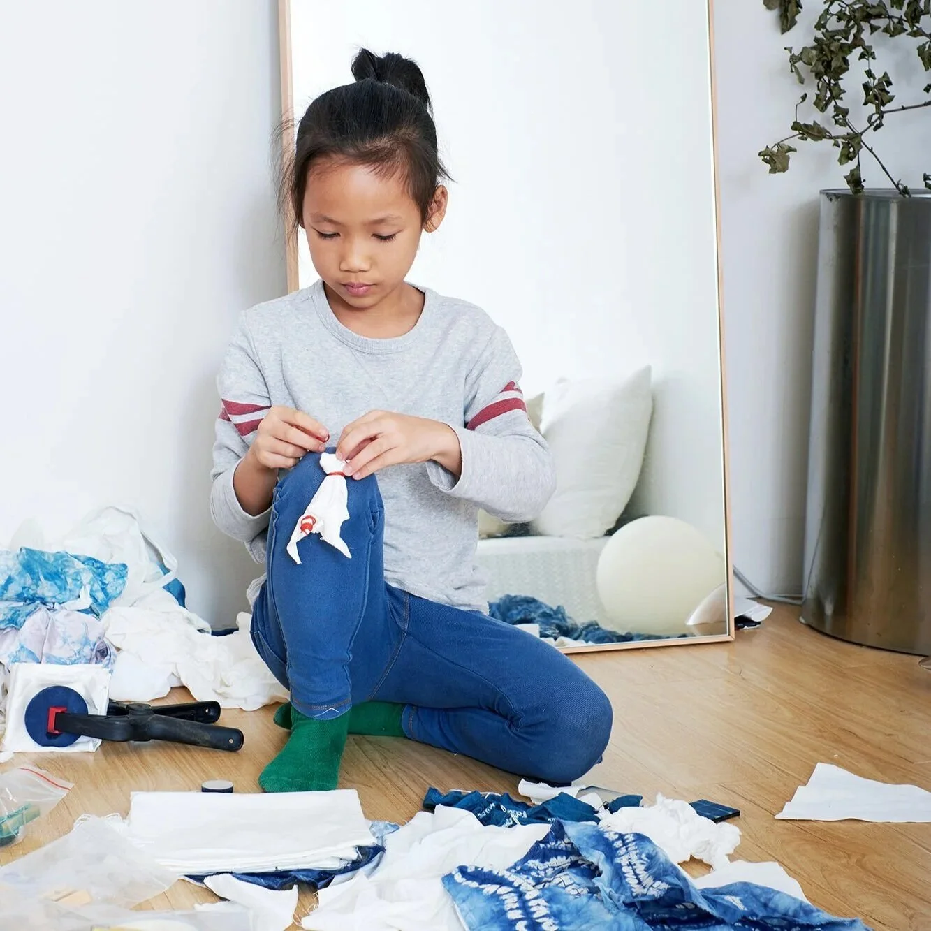 Child creating fabric crafts through hands-on learning activities.