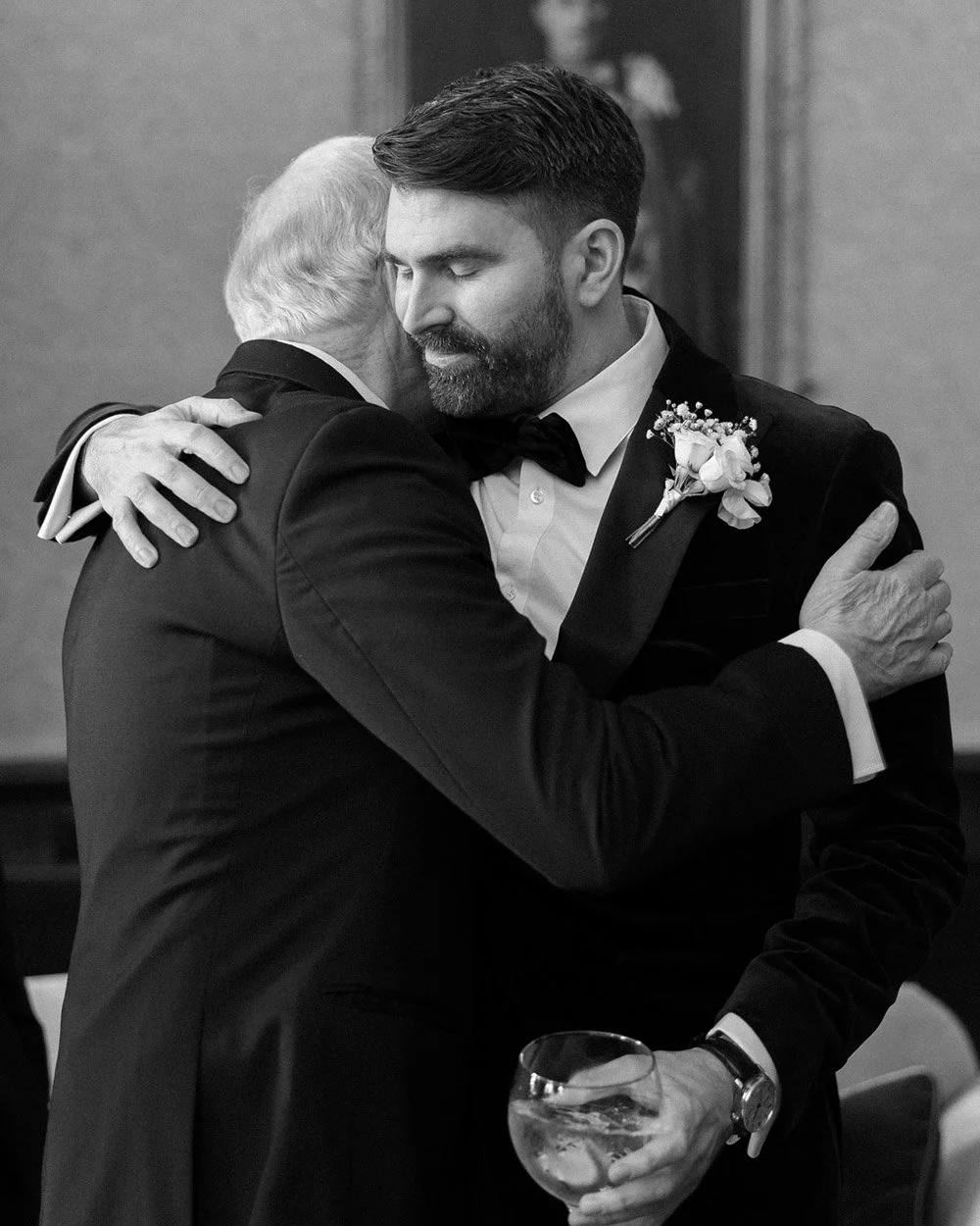 emotional hug of groom and dad in black and white