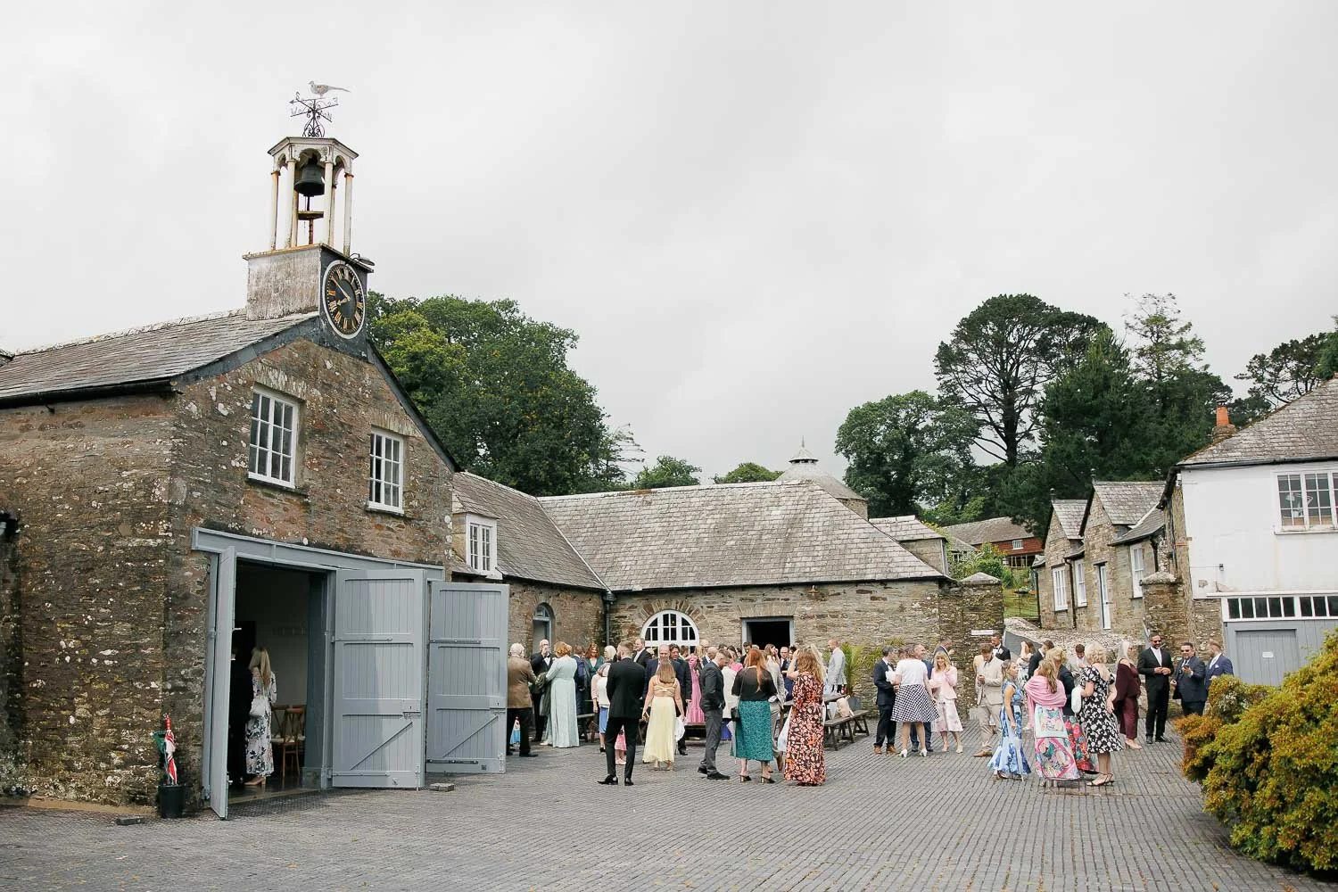 Wedding guests gathering in the courtyard of Boconnoc Estate