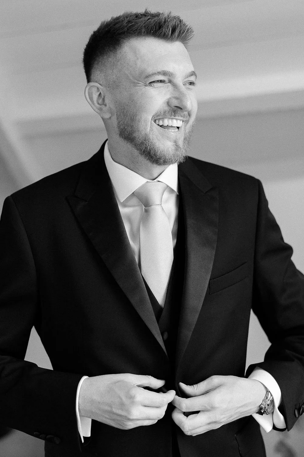 black and white portrait of the groom laughing