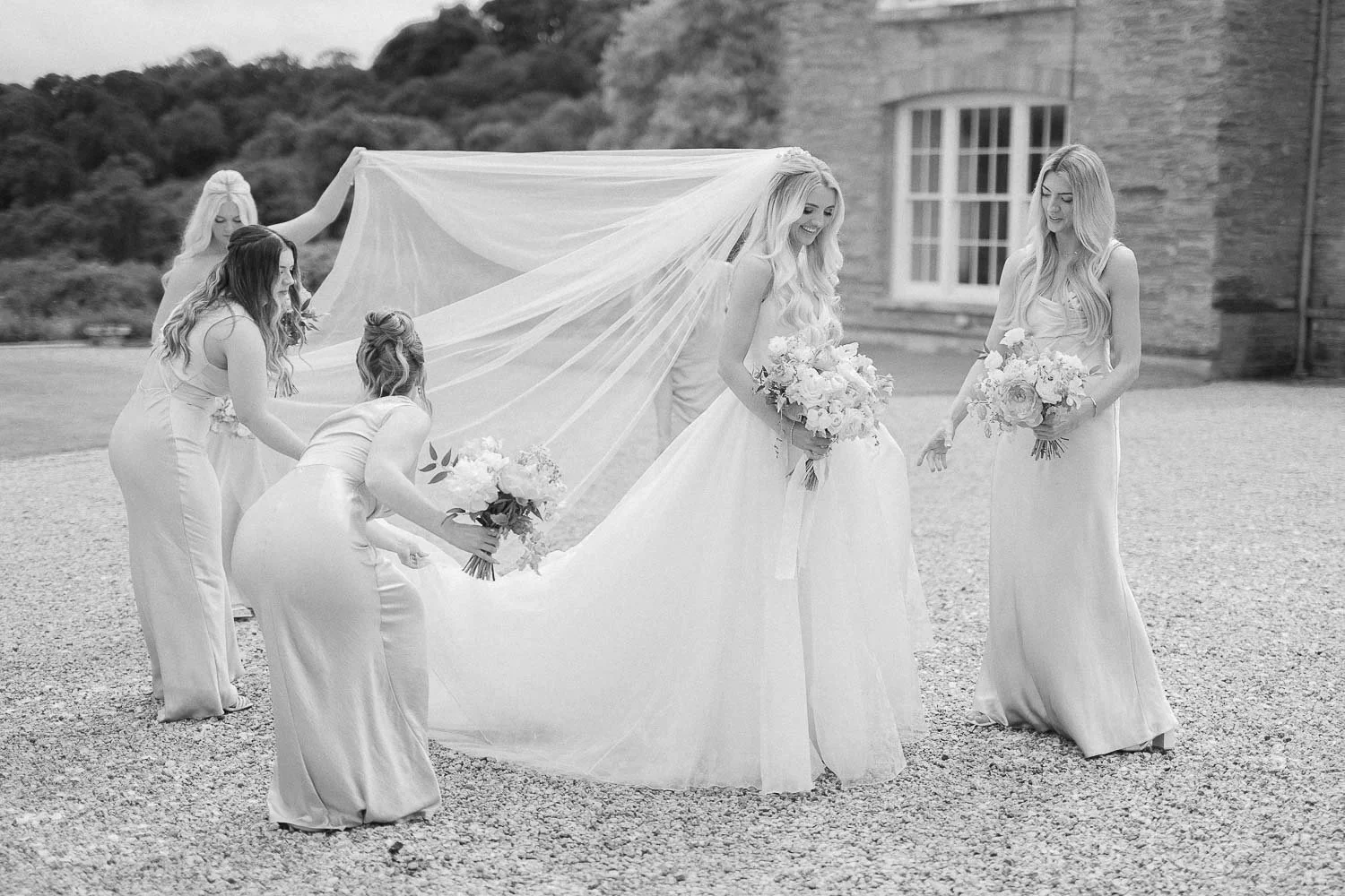 bridesmaids helping with dress and veil of the bride