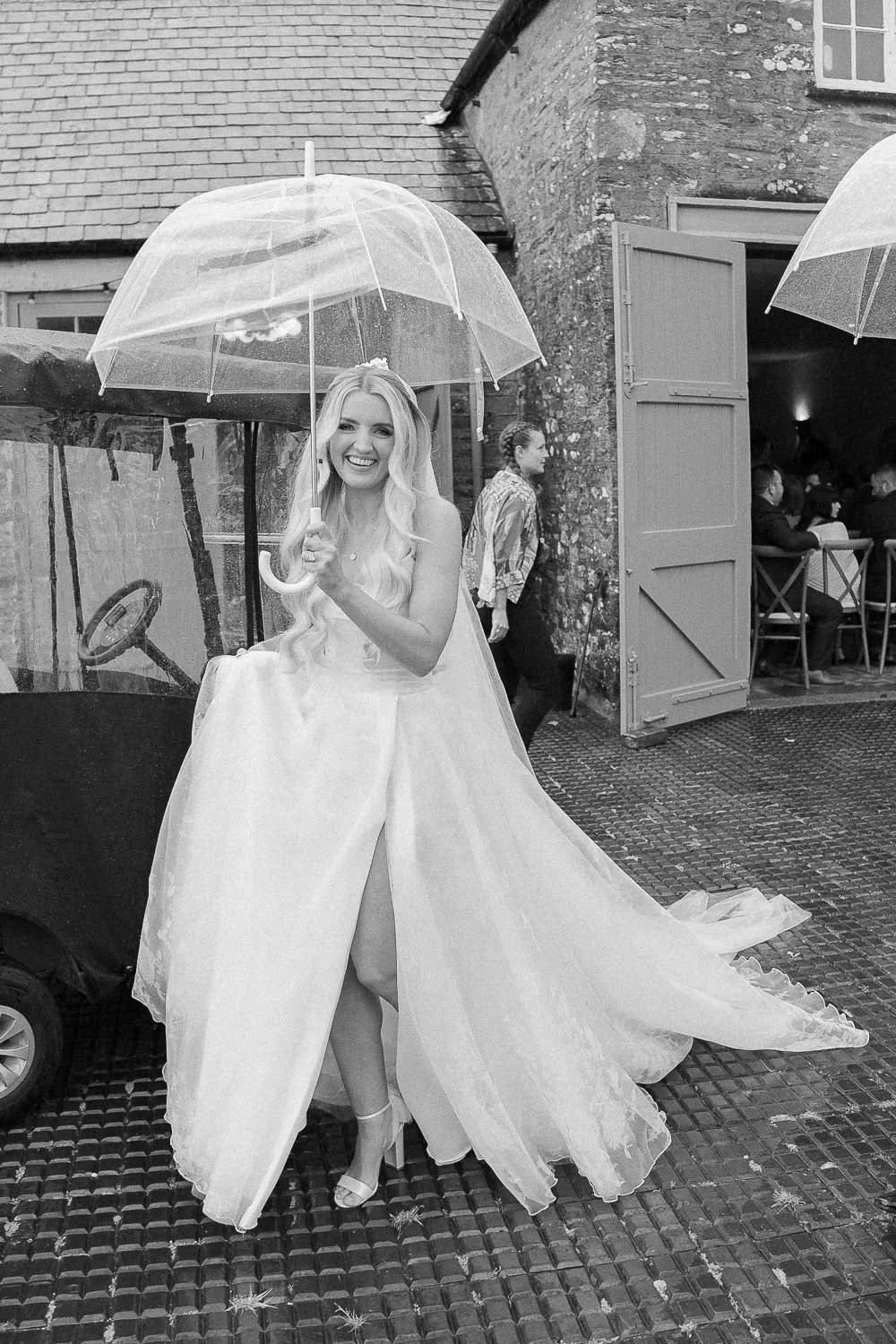 Bride with umbrella walking and smiling