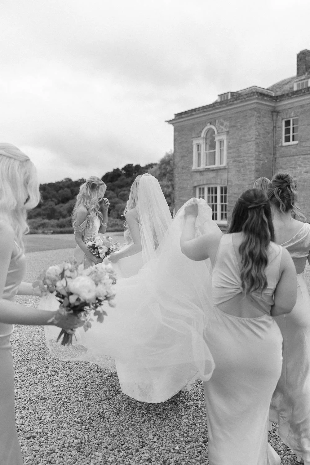 Bridesmaids helping with train of wedding dress