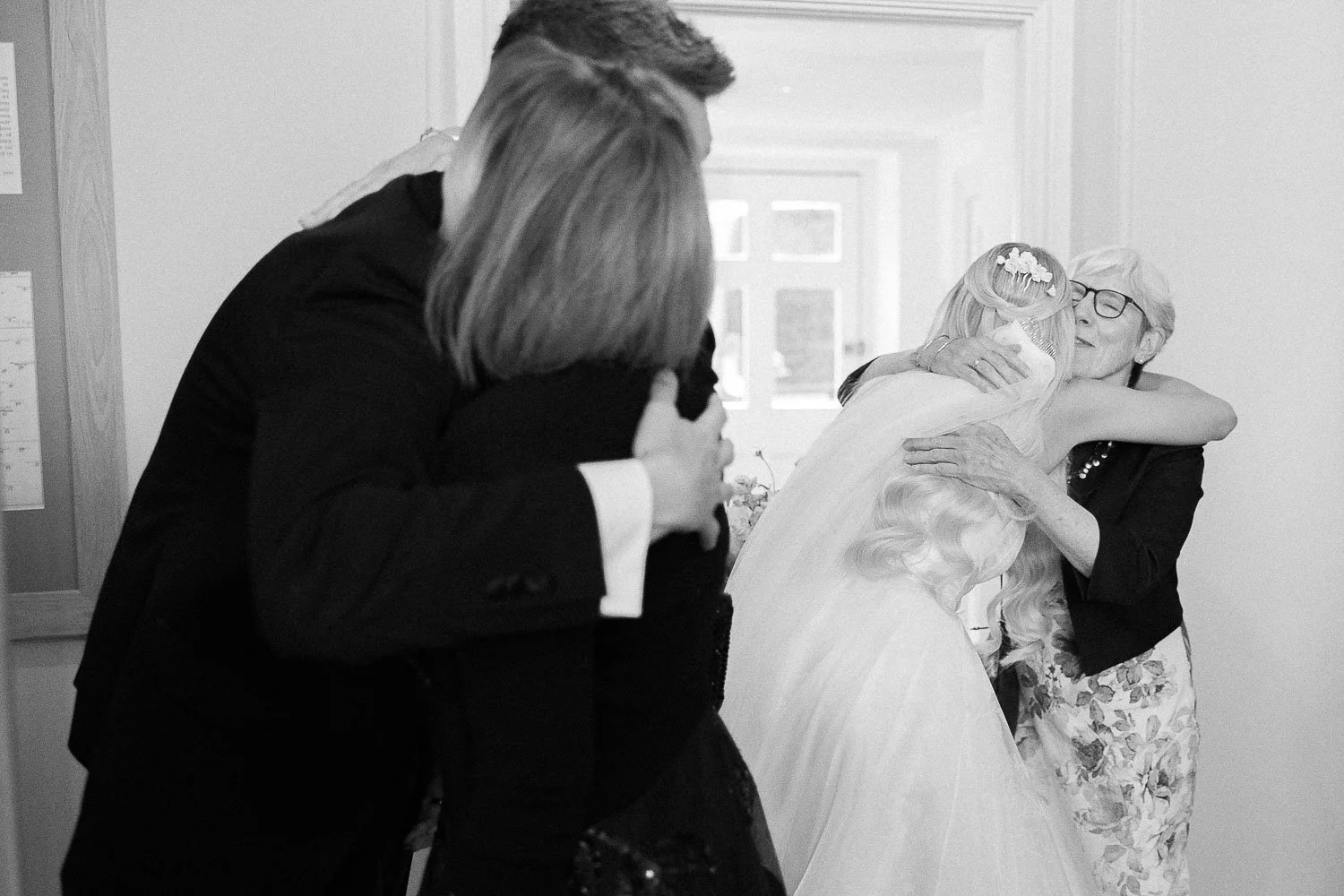hugs with wedding guests in black and white