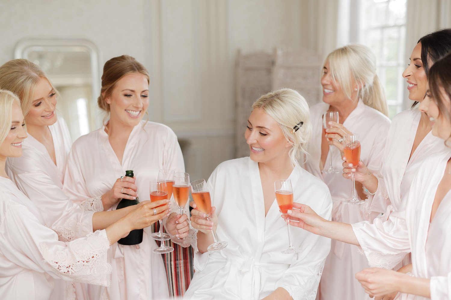 A cheers with the bridesmaids in a light & airy room