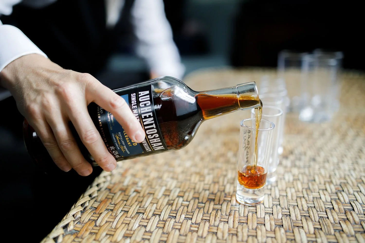 groom pouring whiskey into glass, detail photo