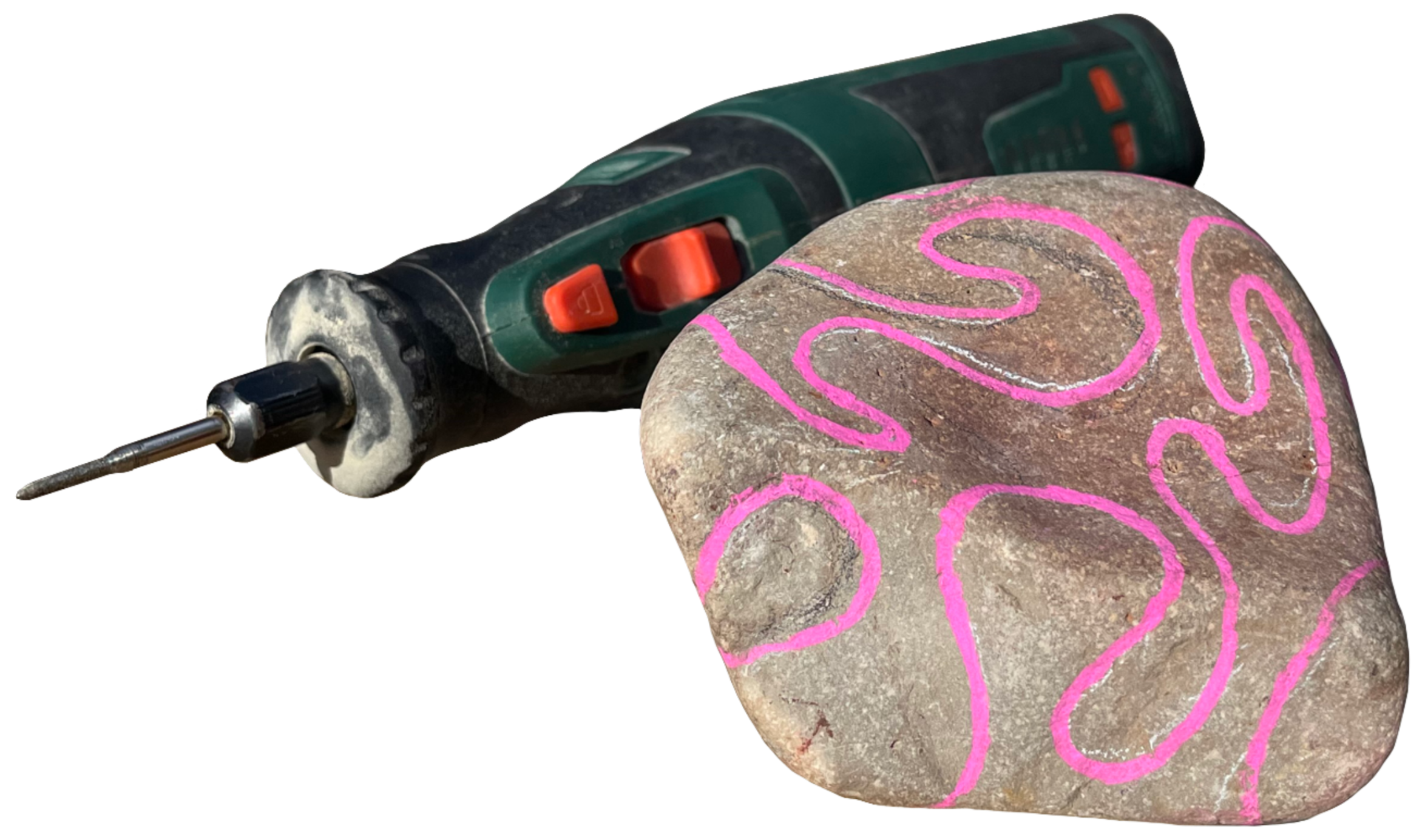 A cordless electric rotary drill with a green and black body and orange buttons, resting on a large rock painted with pink swirling lines.