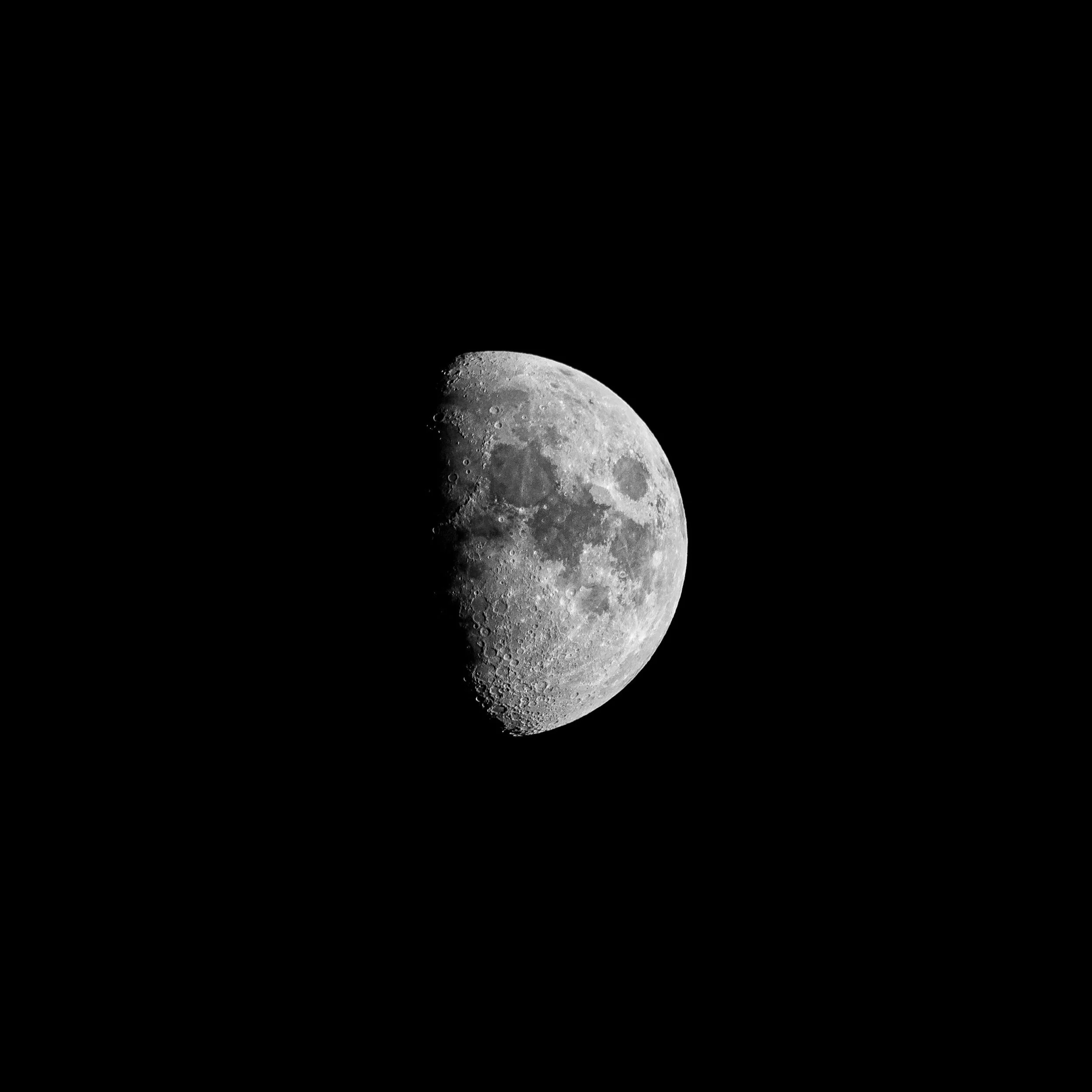 Black and white photo of the moon showing detailed craters and surface features.