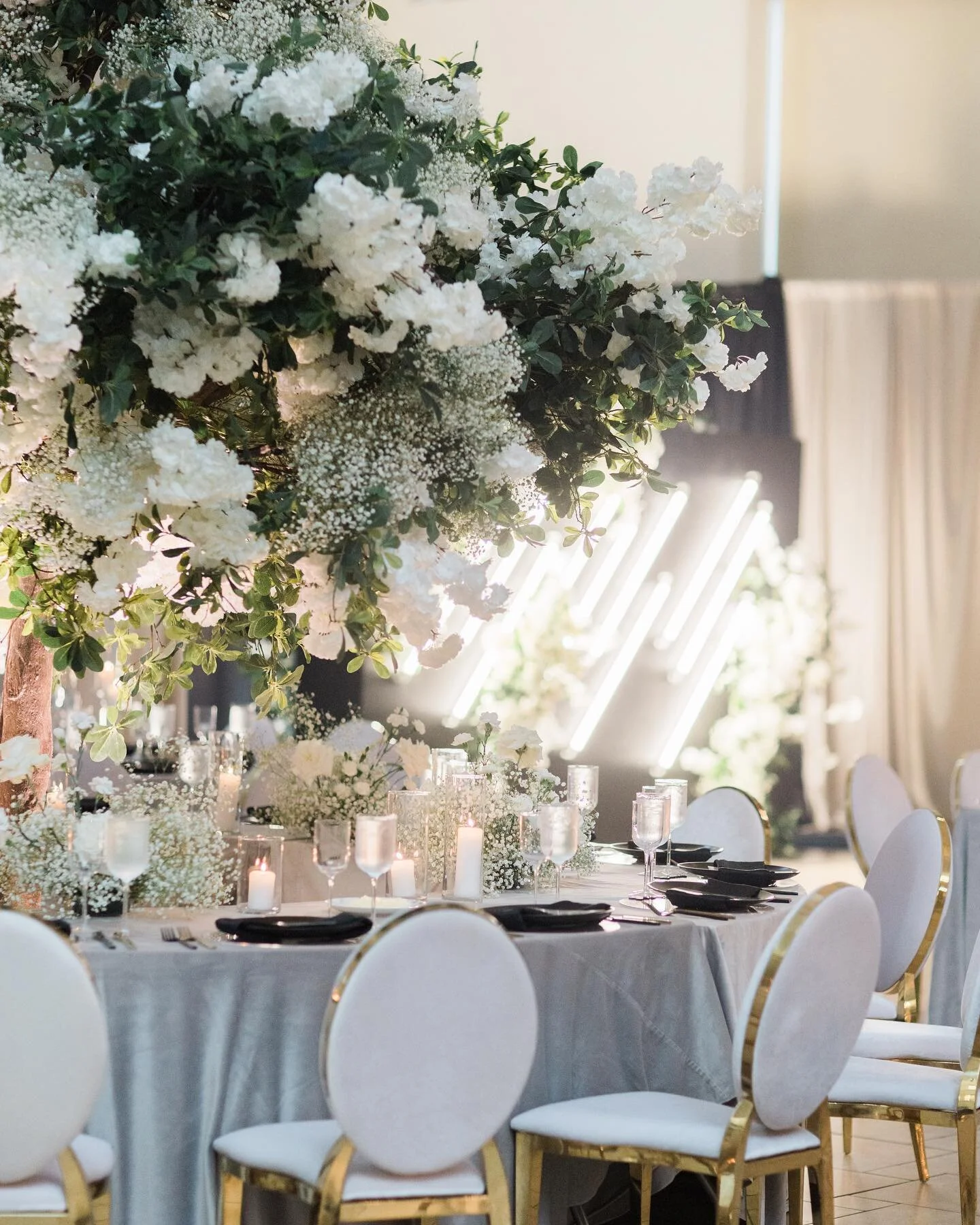 We love anything &ldquo;tree&rdquo;. What That means is, we will gladly and enthusiastically incorporate a tree into your design anywhere, anyhow, and anyway we can. I this case filling them with layers of white blooms and using them as centerpieces 